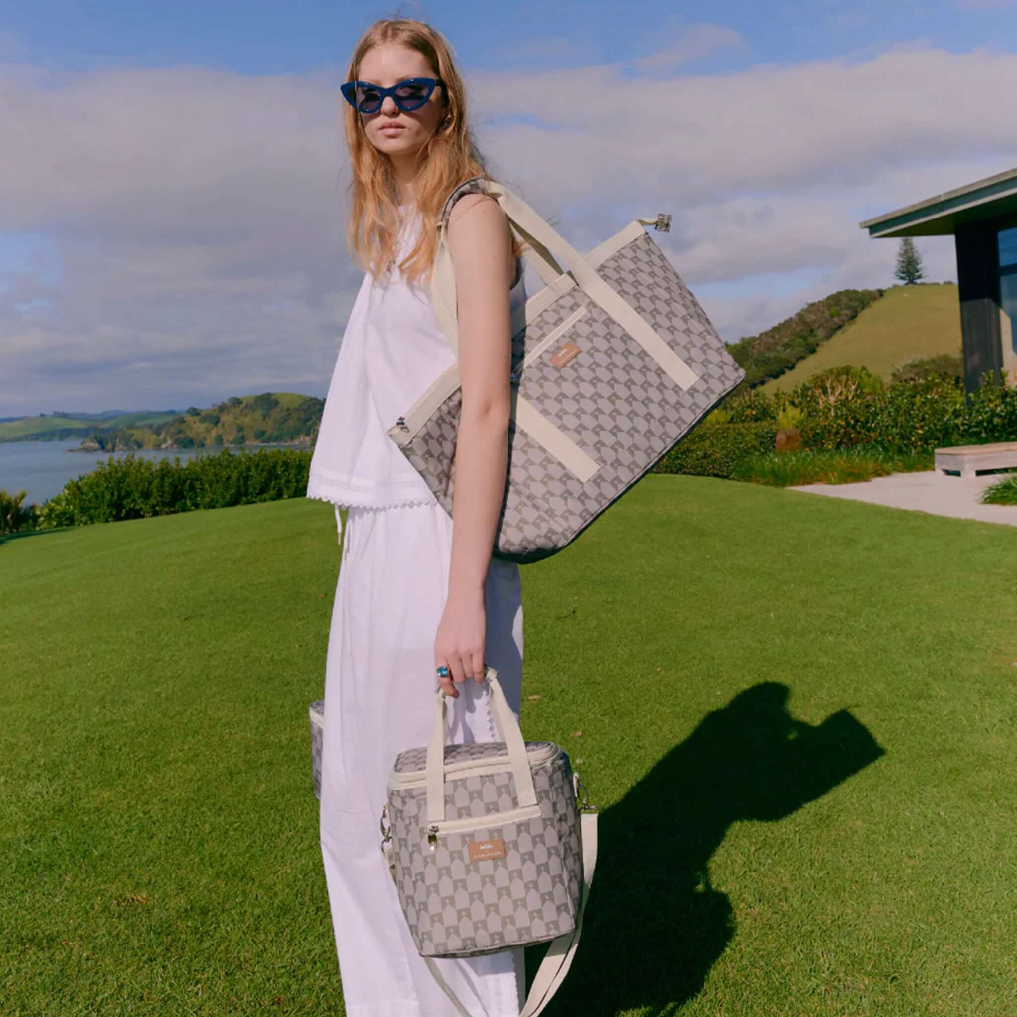 Kollab x Karen Walker Tote Bag - Sage Monogram carried on shoulder outdoors, NZ-inspired monogram print holiday tote