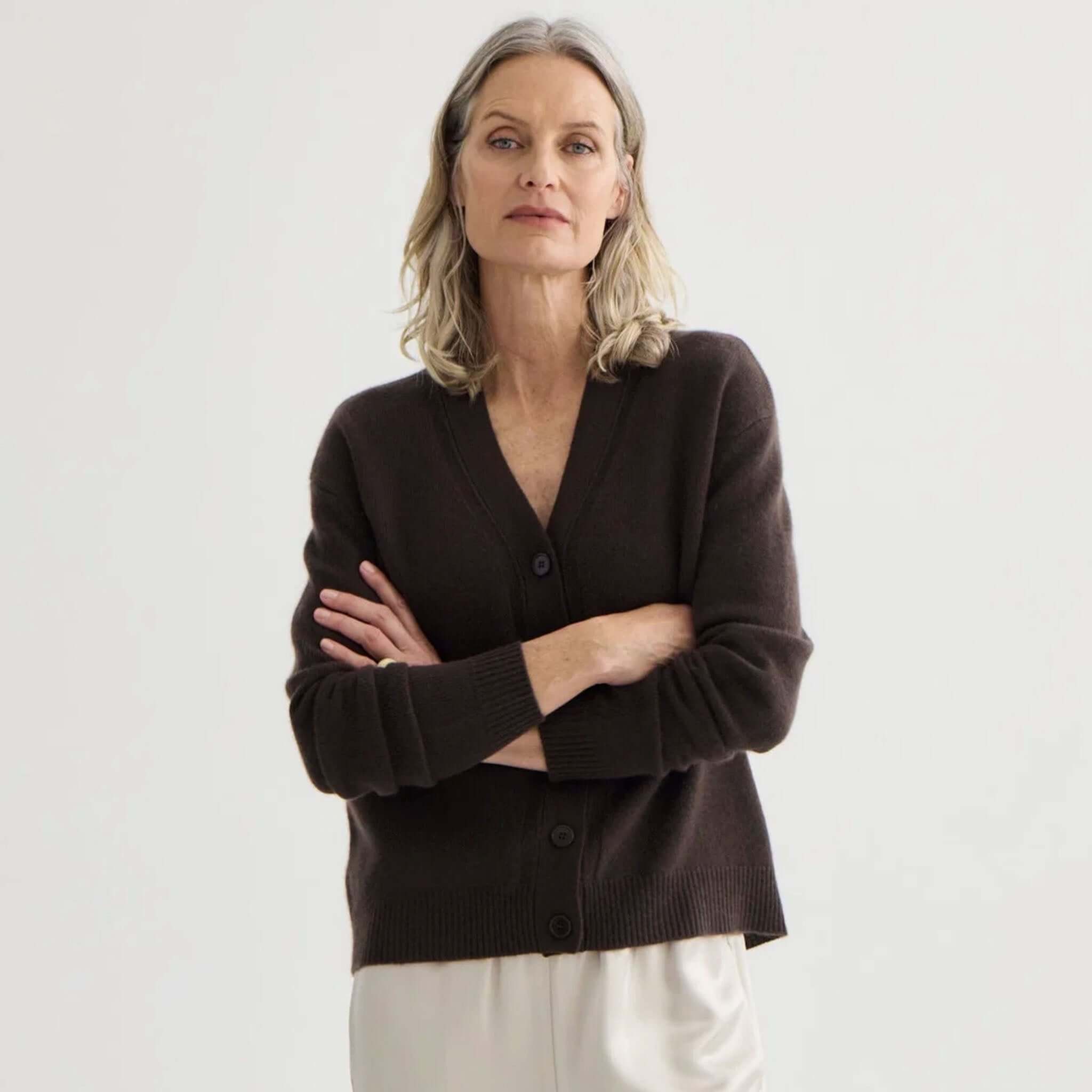 Laing Cashmere V-Neck Cardigan - Bitter Chocolate worn by a model with arms crossed, showcasing its luxurious design.