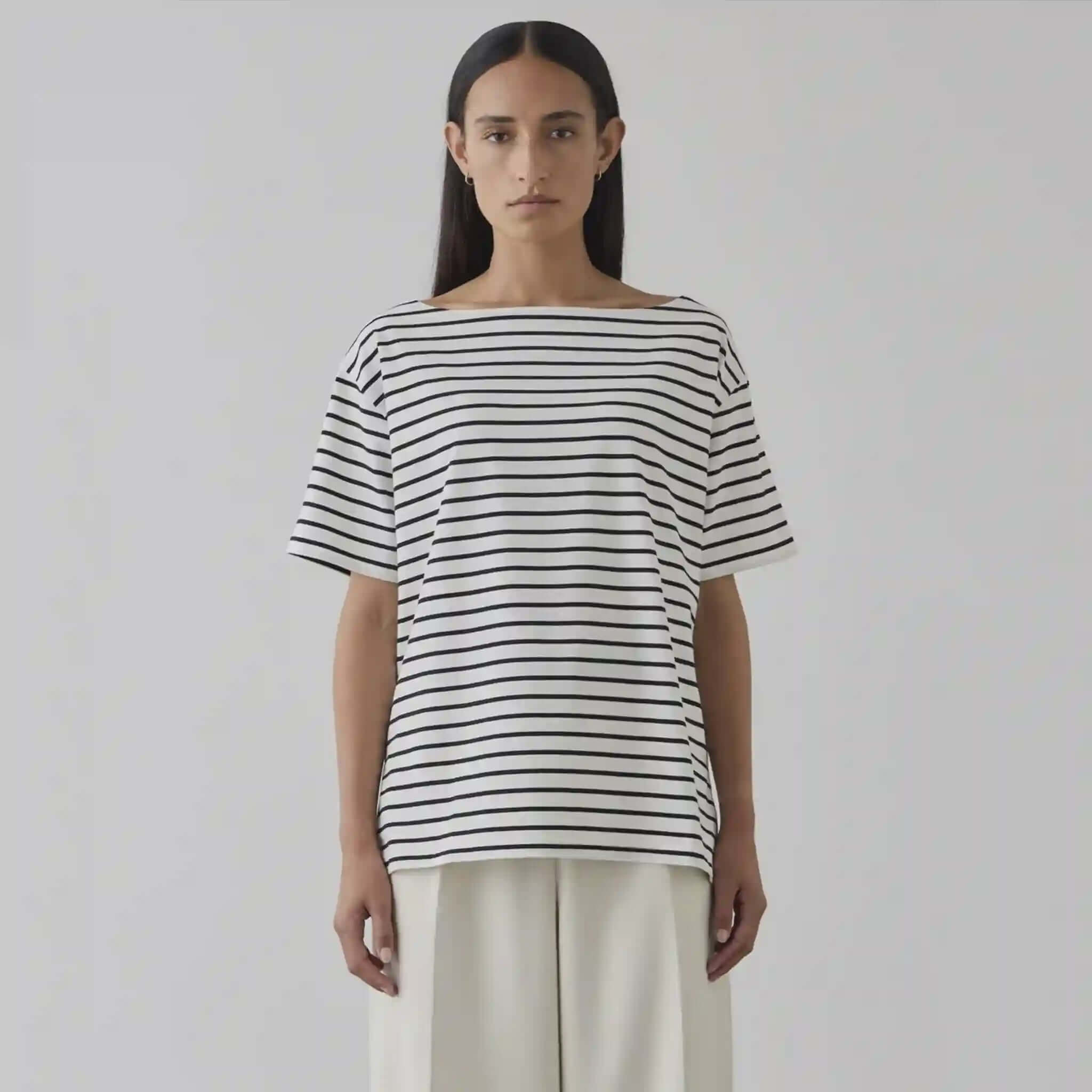 Person wearing a black and white striped shirt against a plain background