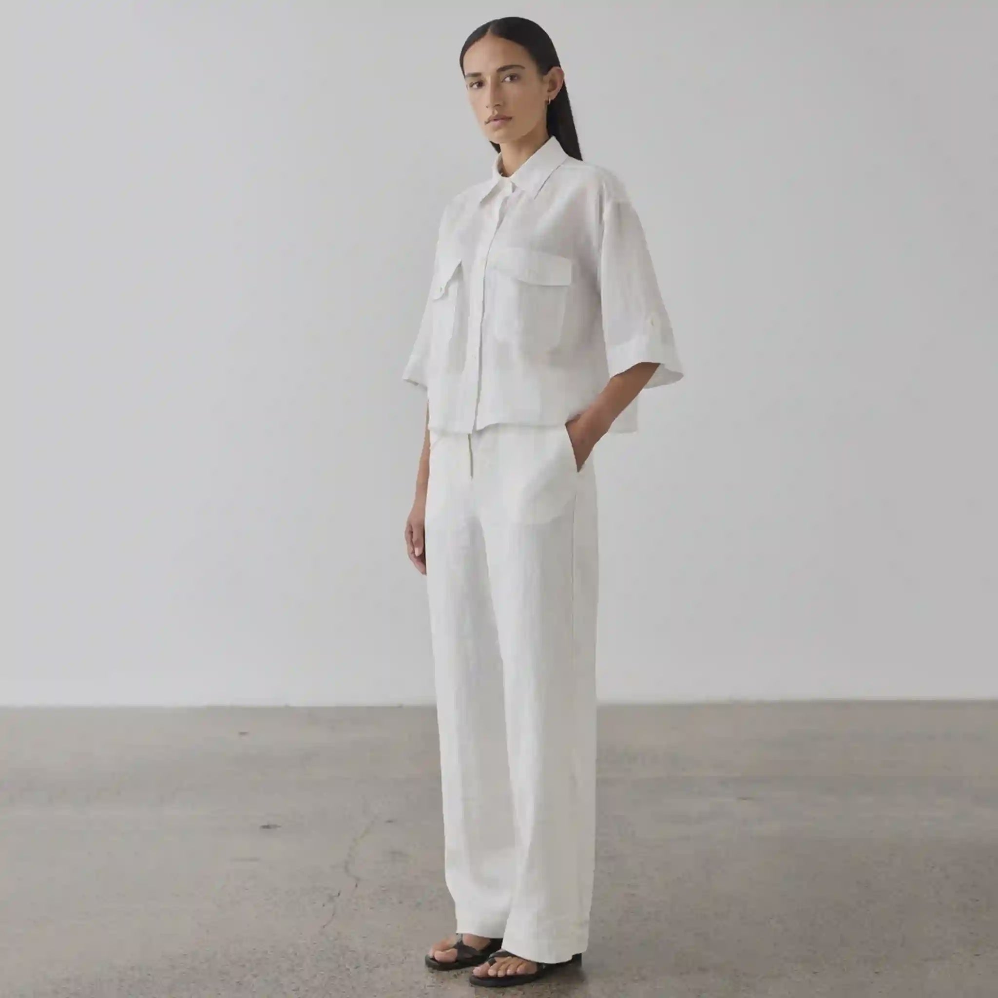 Person wearing a white outfit standing against a plain background