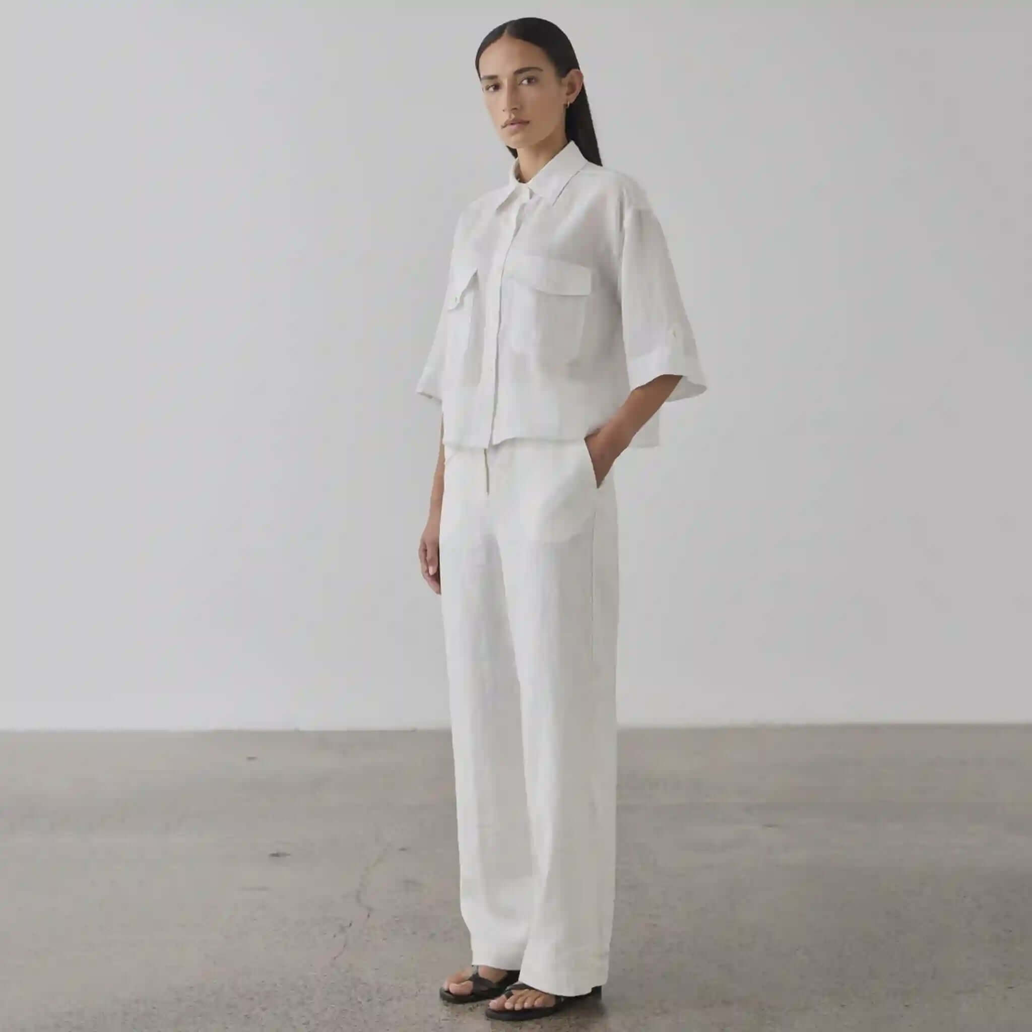 Person wearing a white outfit standing against a plain background