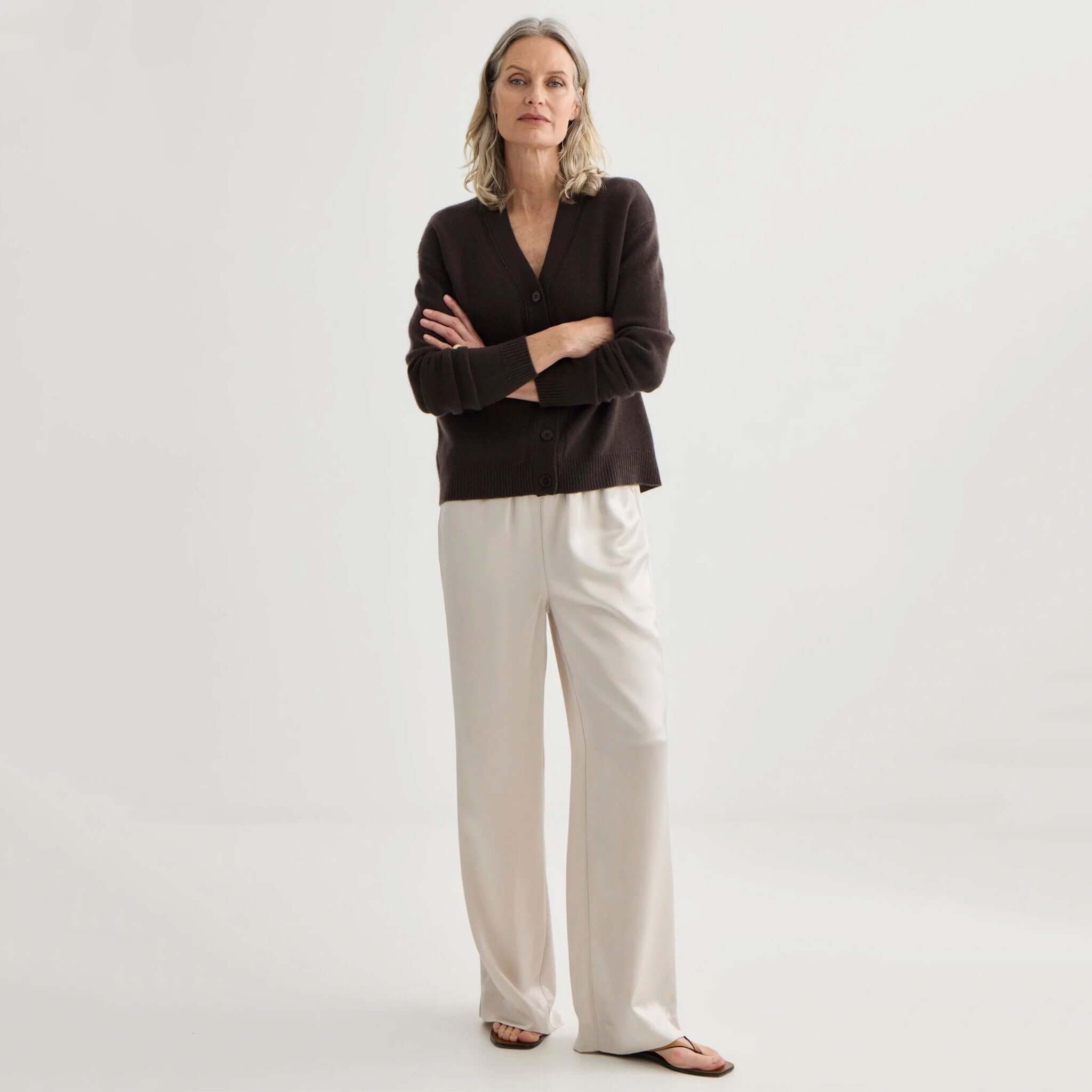 Laing Cashmere V-Neck Cardigan - Bitter Chocolate worn with light-colored trousers, giving a stylish and elegant look.