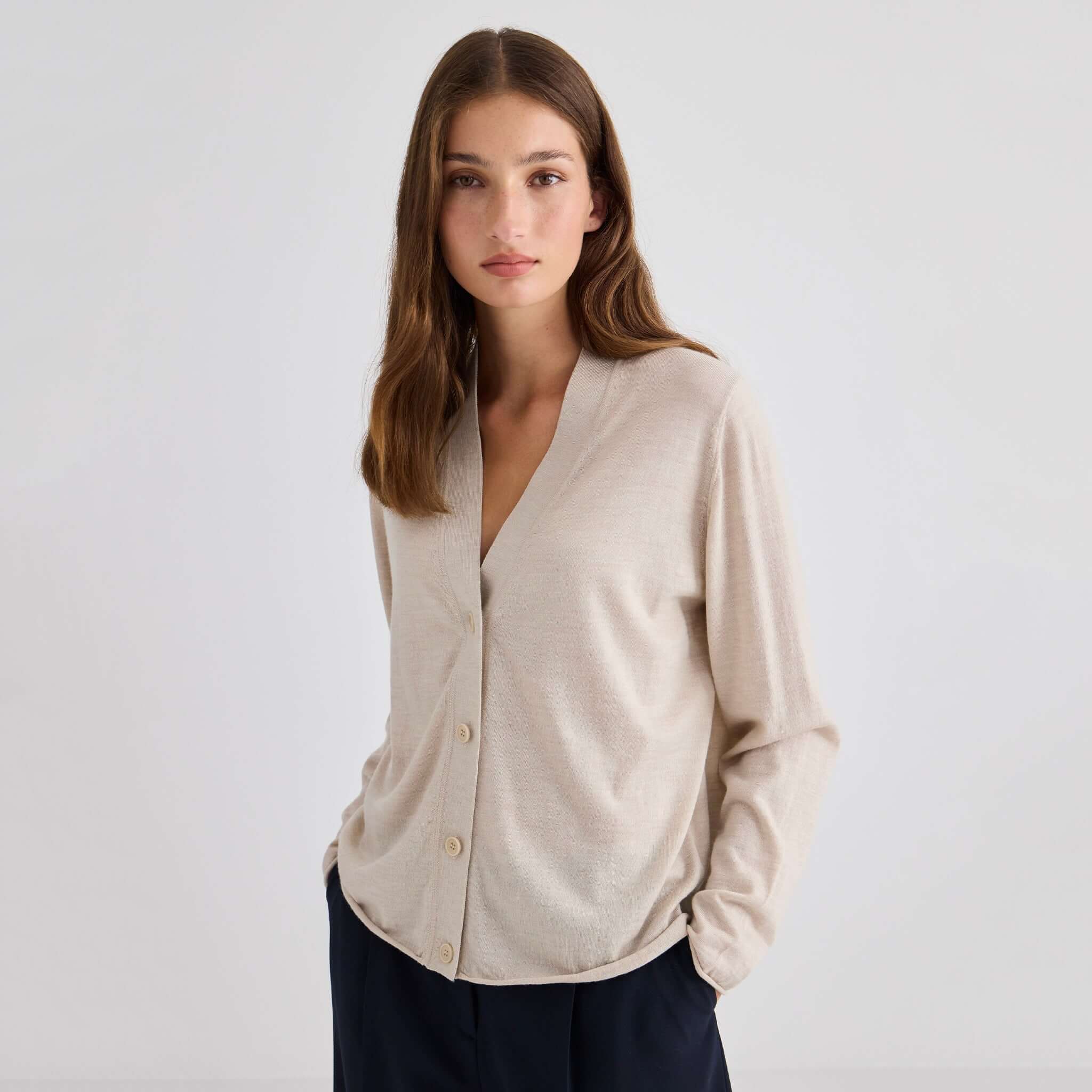 Laing Liv V-Neck Merino Cardigan - Sand worn by a model, showcasing its relaxed fit and fine Merino quality.