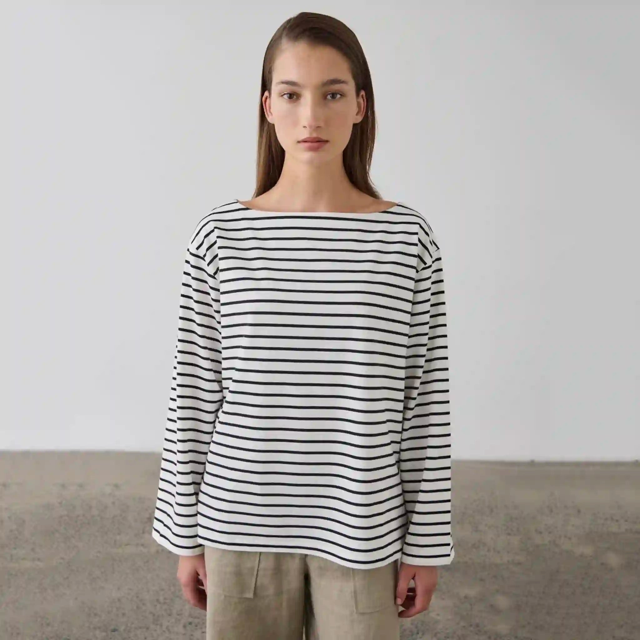 Person wearing a black and white striped long-sleeve shirt against a plain background