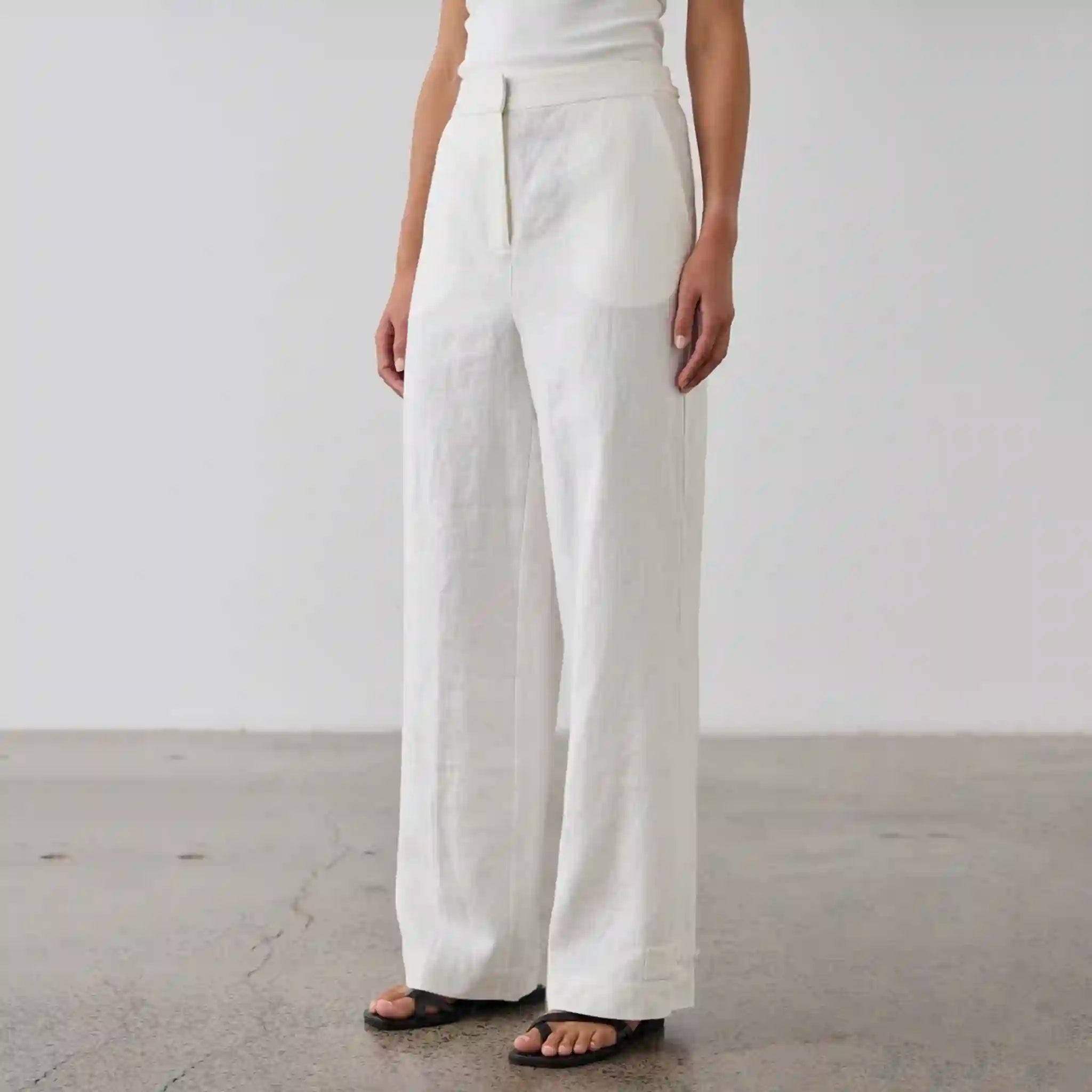 Person wearing white wide-leg pants on a plain background
