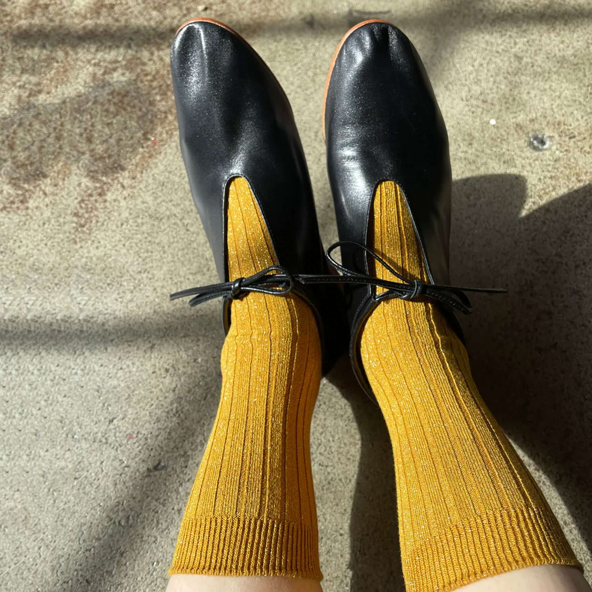 Le Bon Shoppe Her Lurex Socks - Mustard Glitter ribbed glitter socks worn with black flats, mustard shimmer crew socks lifestyle photo