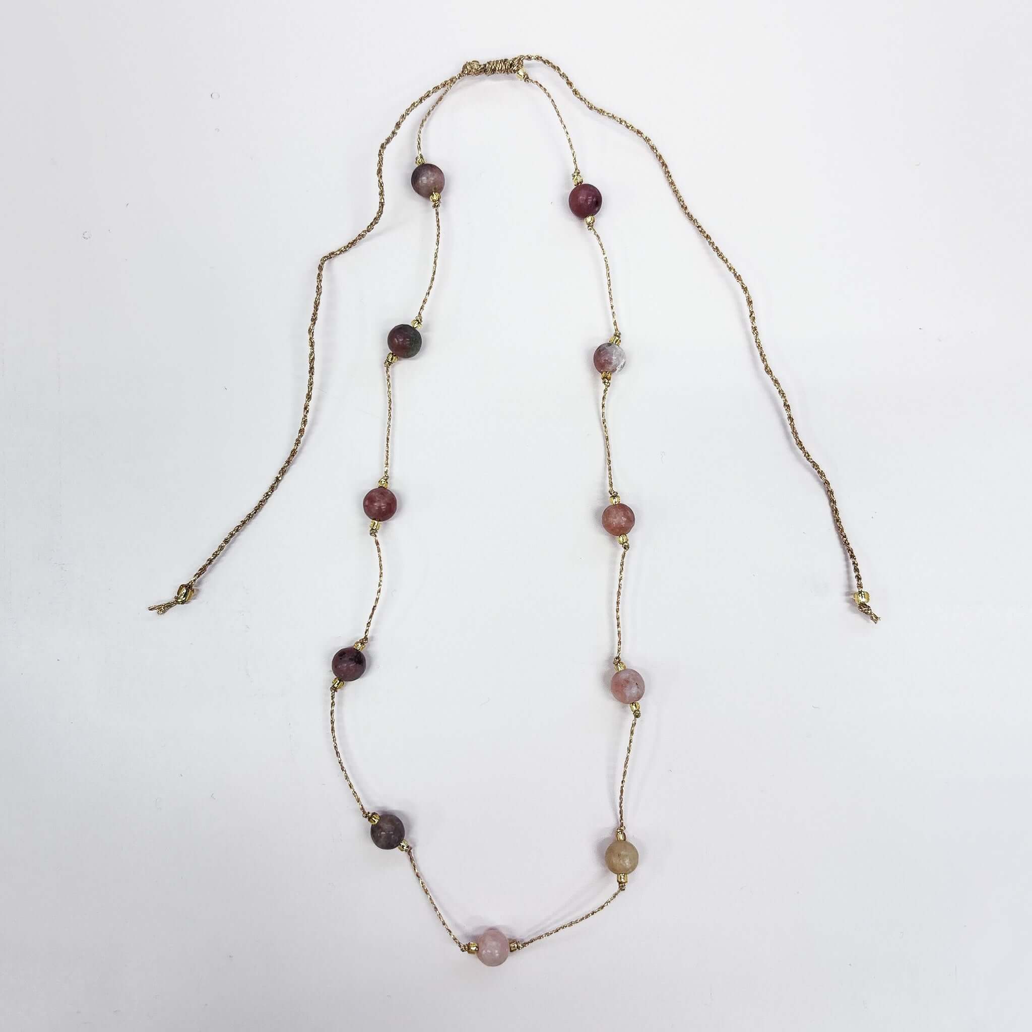 Margaret Loretta Necklace featuring smooth rounded stone beads and delicate gold chain in amber tones.