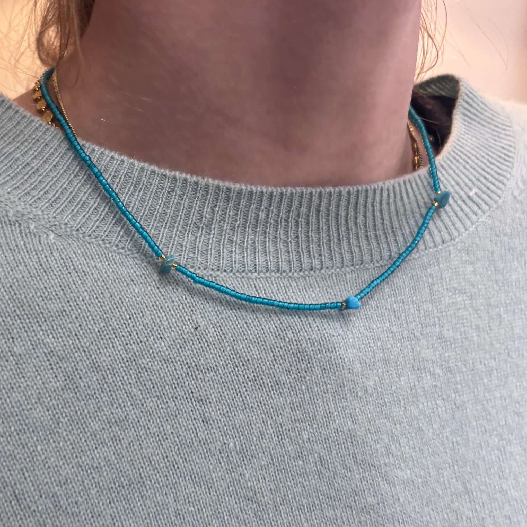 Margaret Elsie Necklace worn on a person's neck, featuring tiny crystal beads and gold spacers.