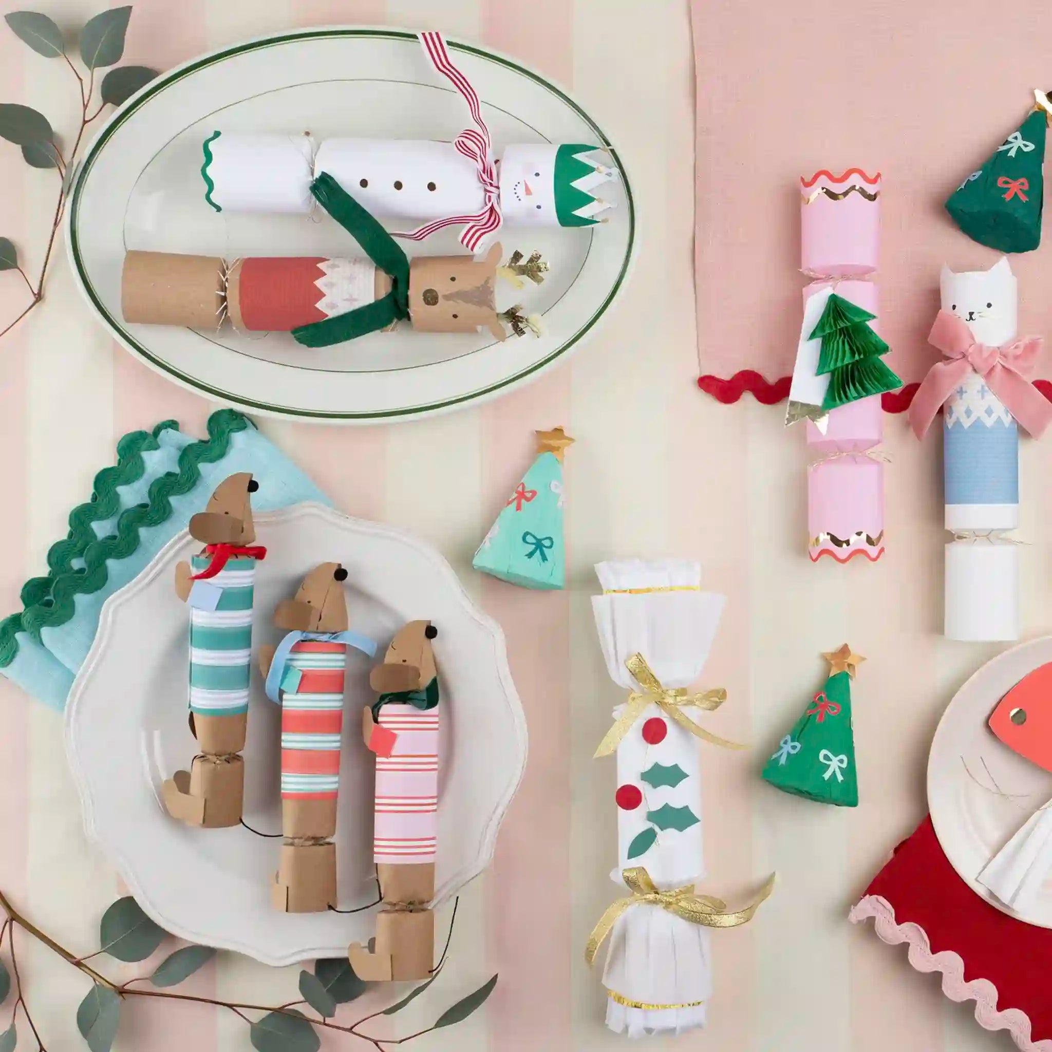Collection of Christmas cracker decorations on a pink background