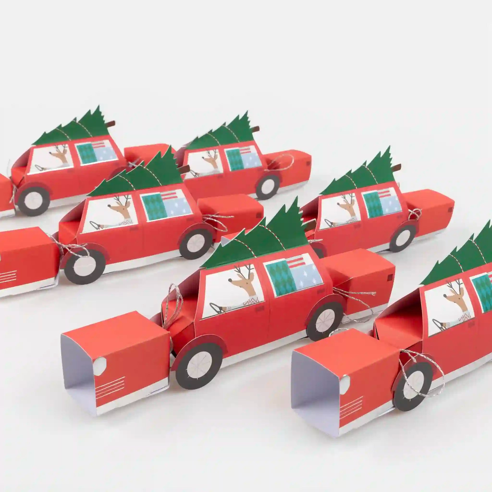 Red paper car crackers with Christmas trees on a white background