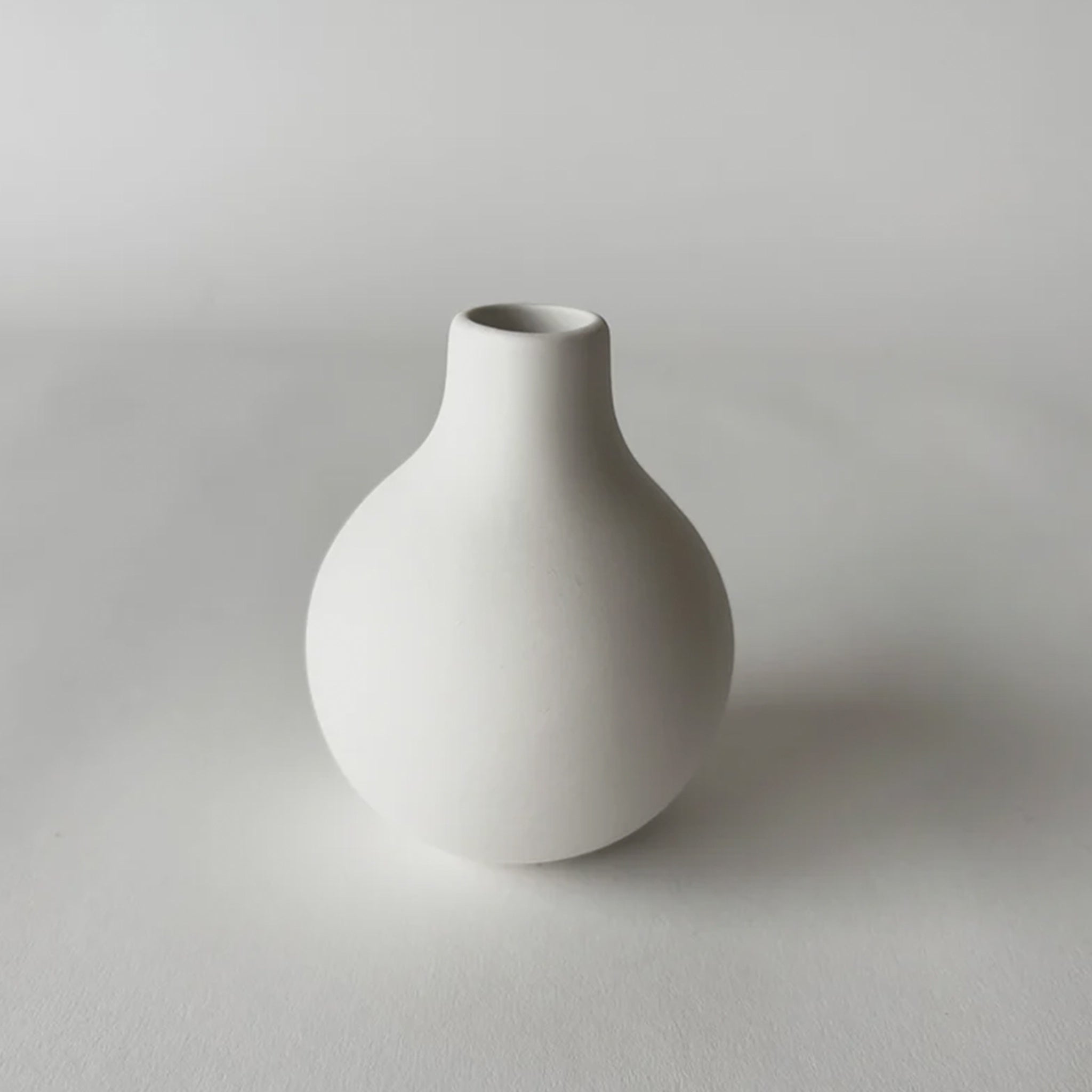 White ceramic vase on a light gray background