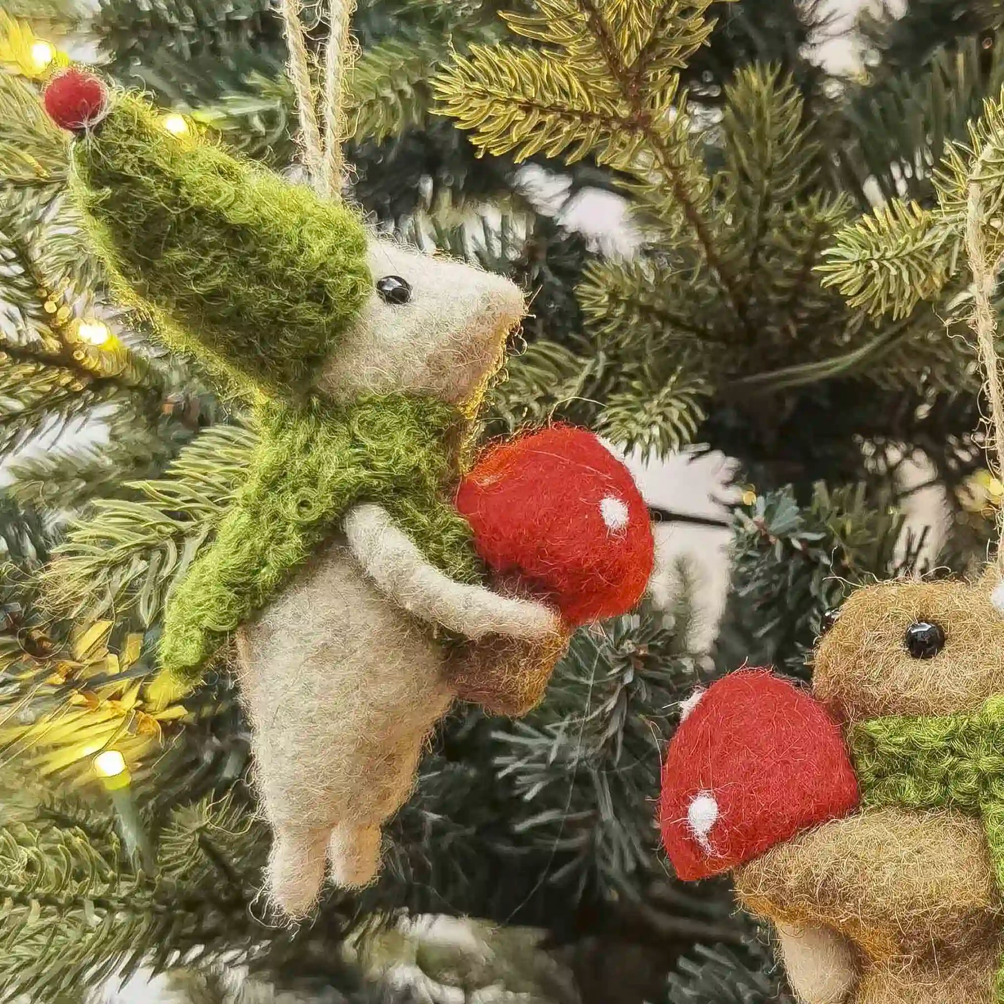 Felted animal ornaments resembling a mouse and a bear on a Christmas tree.