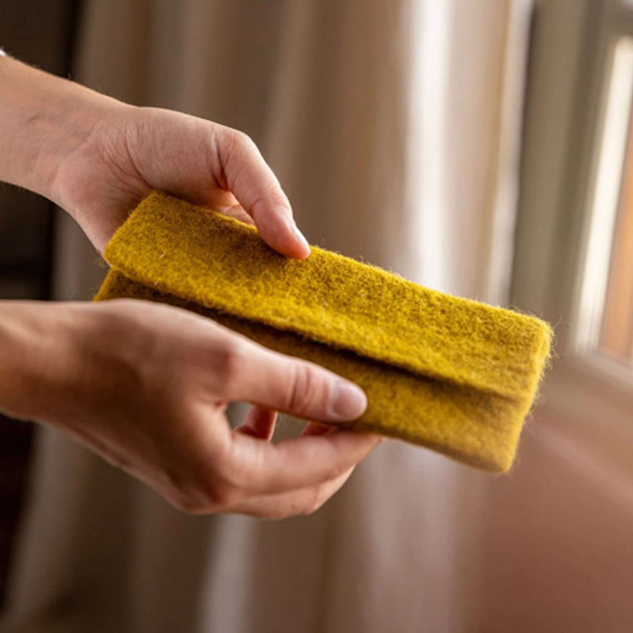 Muskhane Felt Glasses Case - Pistachio held in hand, showcasing the soft handmade woollen felt texture.