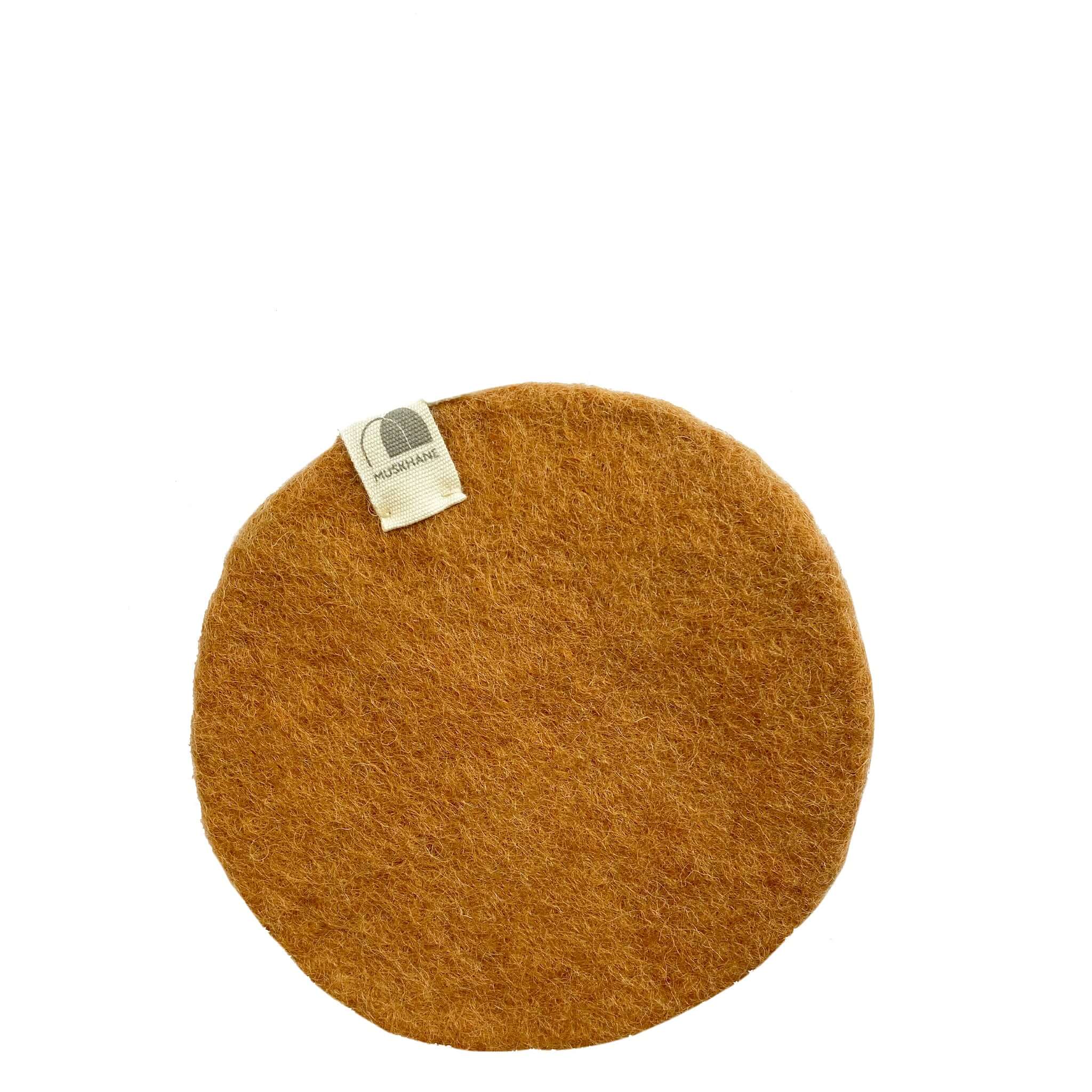 Round brown coaster with a visible brand tag on a white background