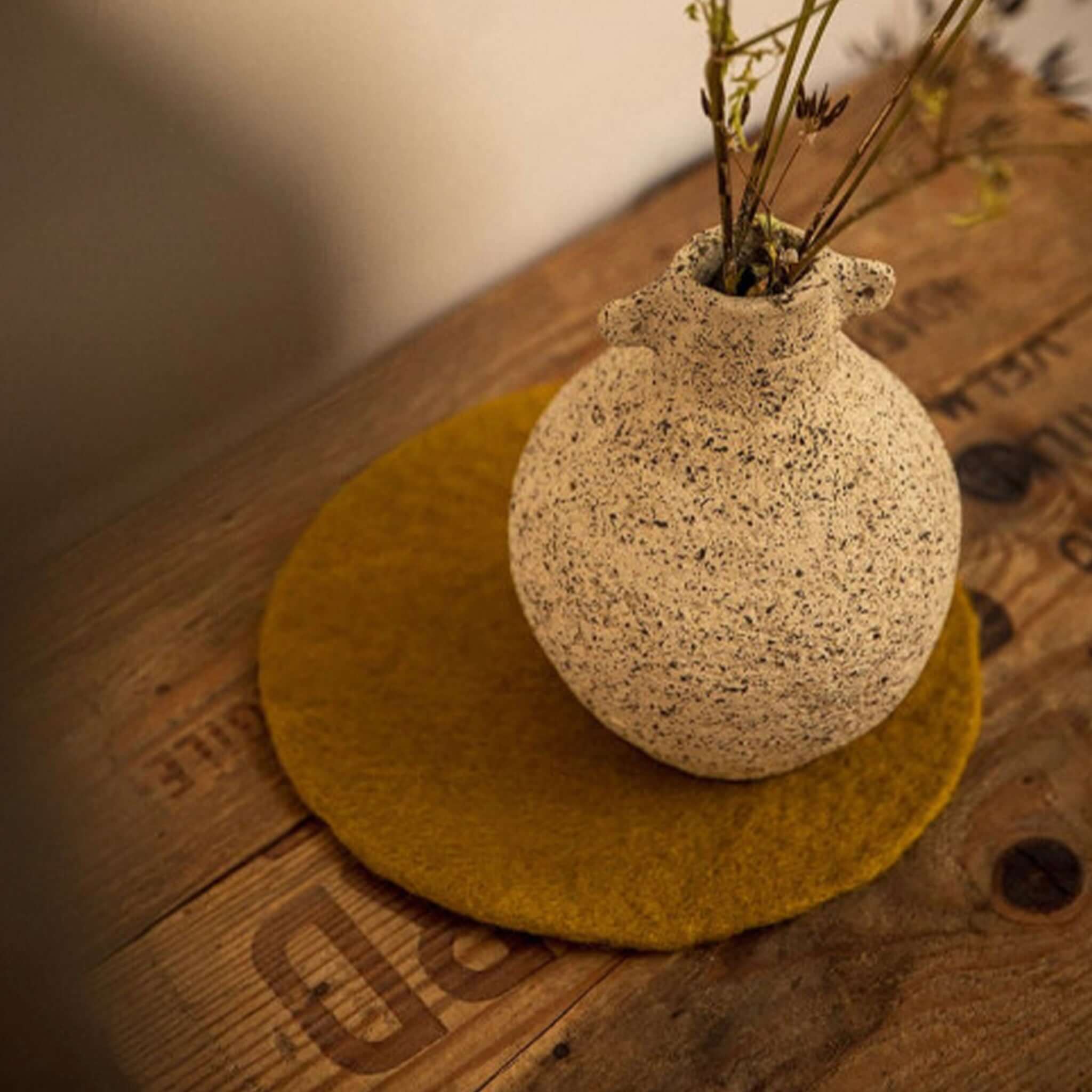 Muskhane Felt Plain Round Coaster - Pistachio felt coaster on wooden table under ceramic vase, 12cm handmade Fairtrade Nepal