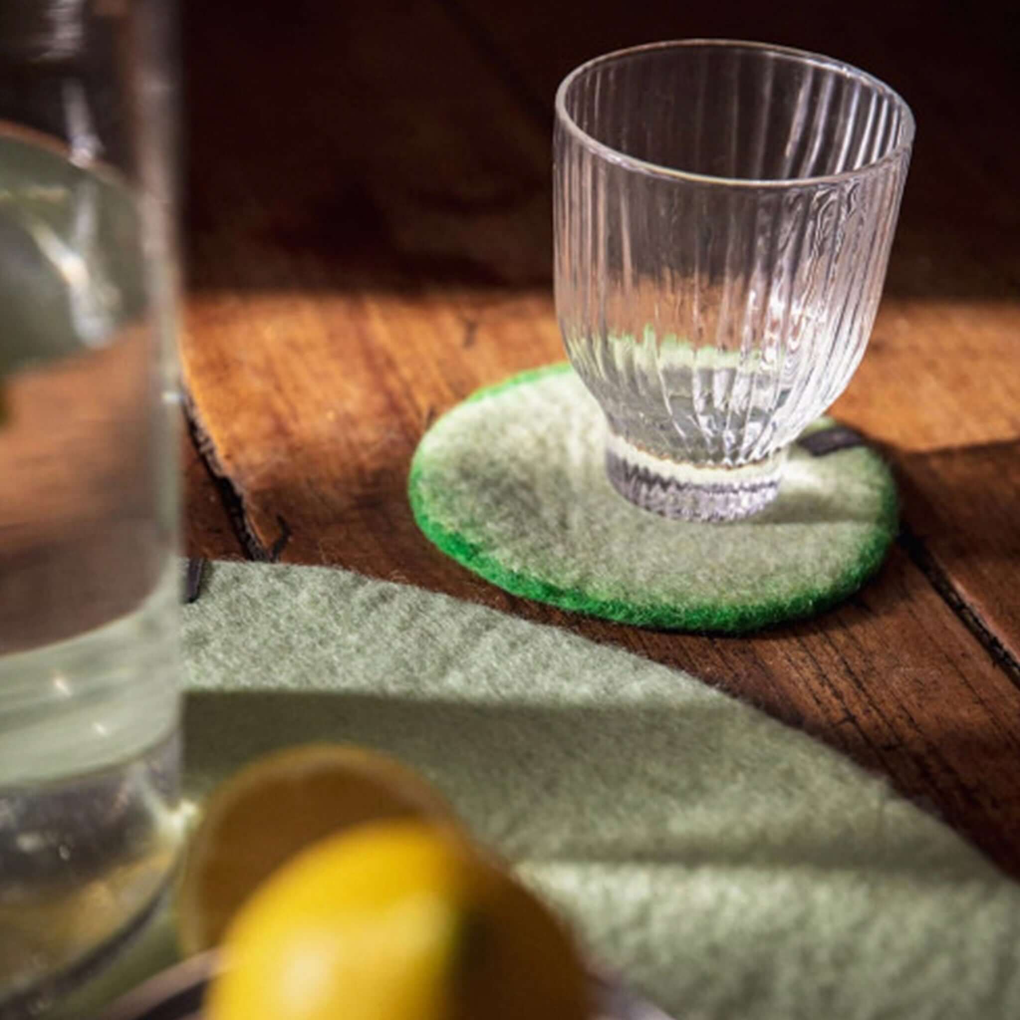 Alt Tag: Muskhane Felt Two Tone Round Coaster - Green & Mint felt coaster under glass, handmade Fairtrade Nepal, 12cm