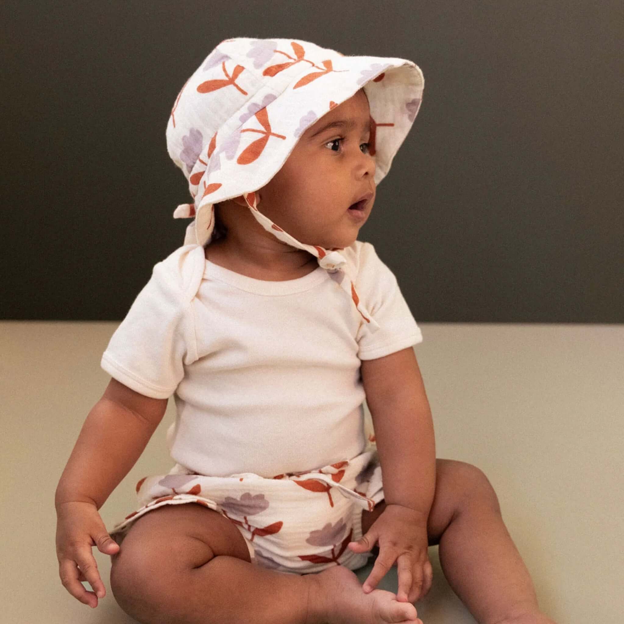 Nature Baby Muslin Sunhat - Fleurette on a baby, offering sun protection and stylish warmth for little explorers.