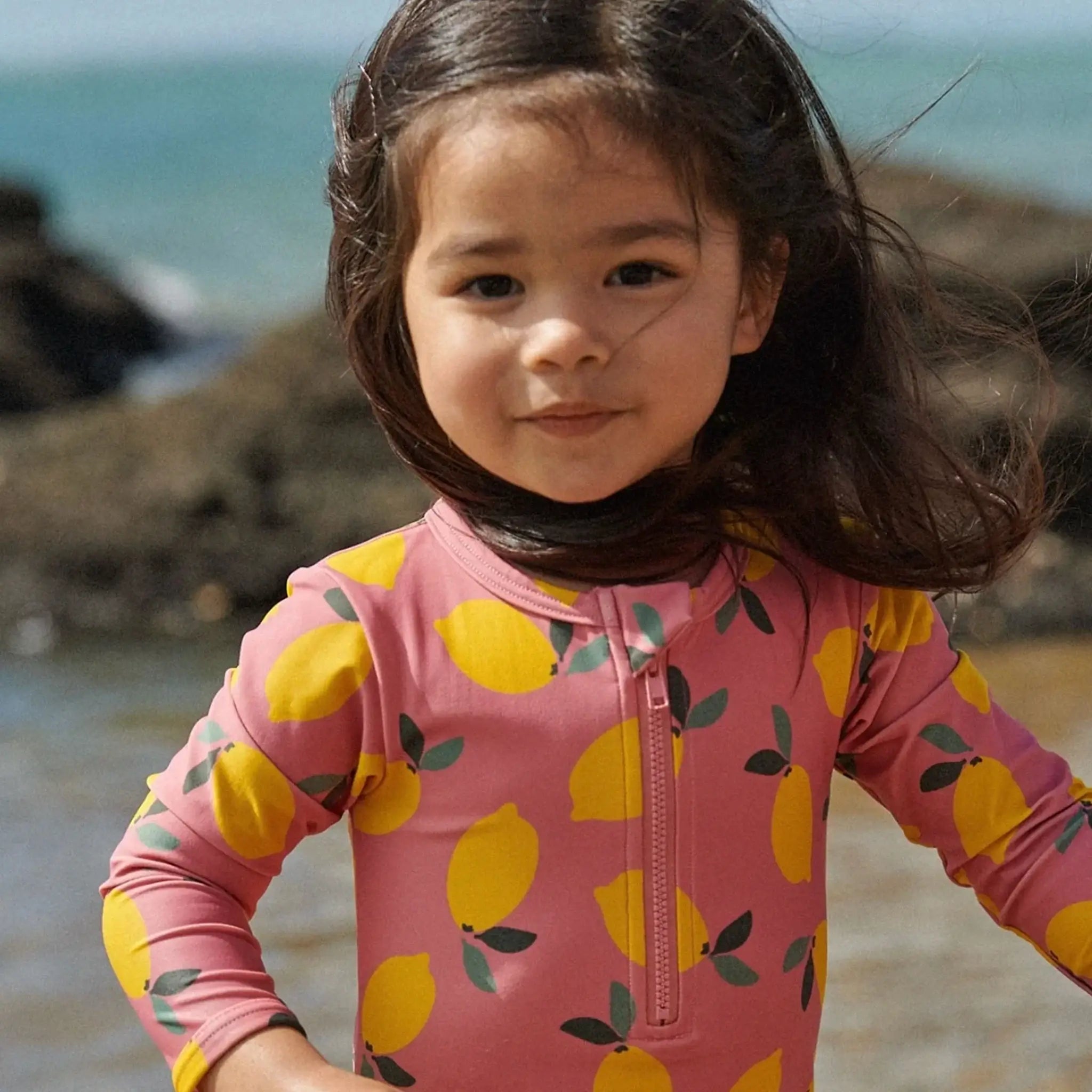 Alt Tag: Nature Baby One Piece Bathing Trunks - Lemmony Rose kids eco one-piece swimsuit with lemon print, full coverage sun-safe swimwear