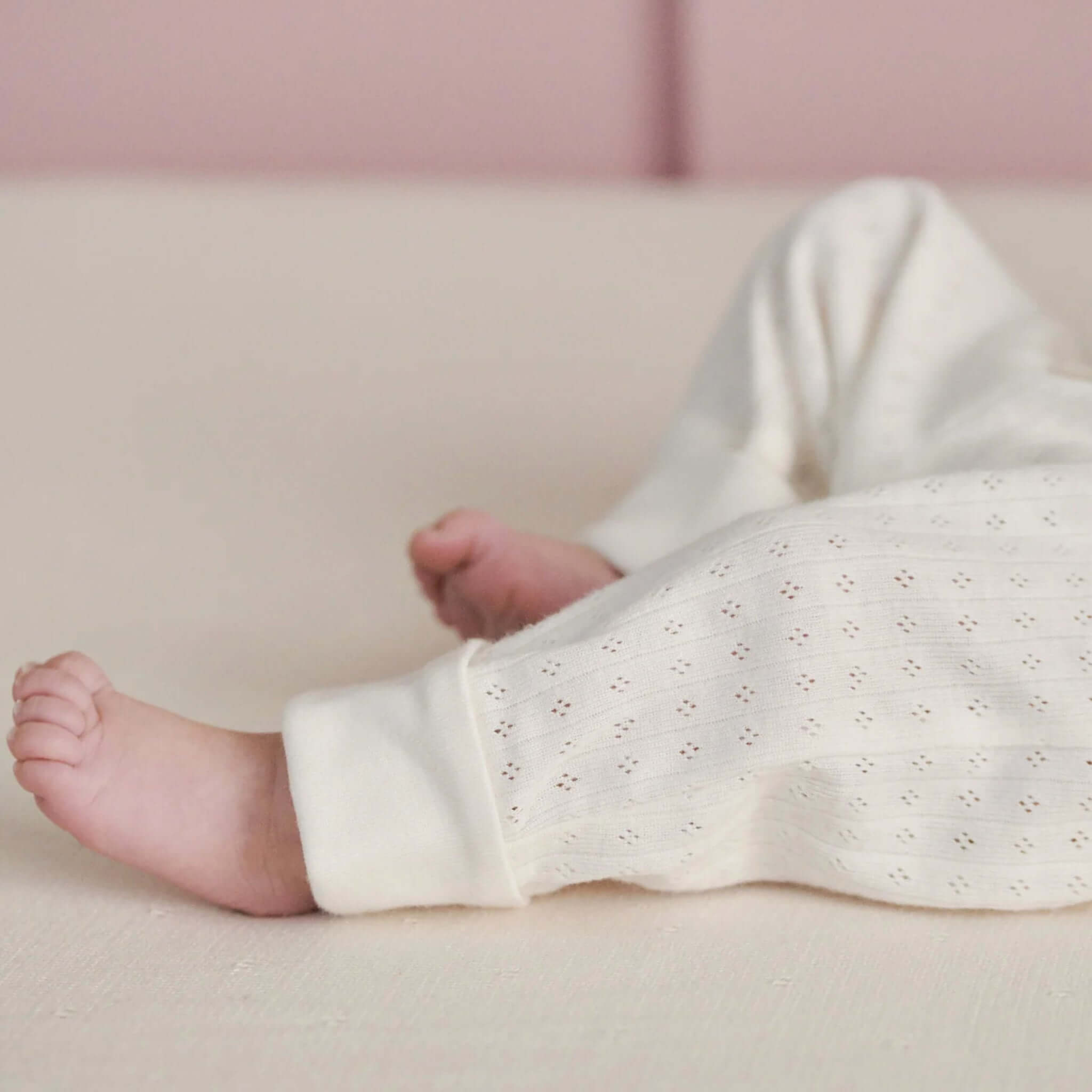 Nature Baby Organic Cotton Drawstring Pants - Pointelle Natural, baby wearing natural pointelle organic cotton pants with cuffed tapered legs