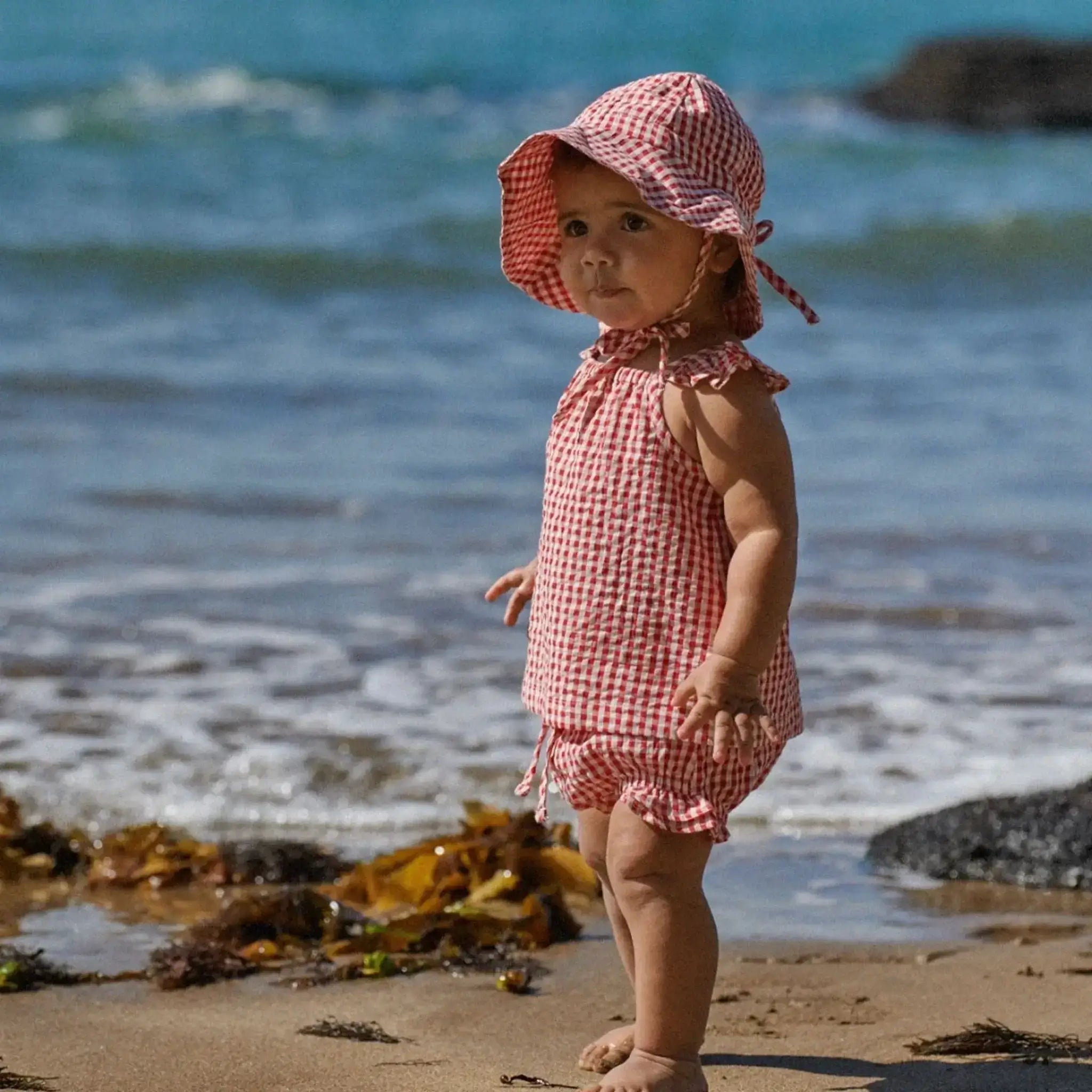 Alt Tag: Nature Baby Organic Cotton Sunhat - Red Check wide brim baby sun hat with chin ties, red check organic cotton canvas beachwear