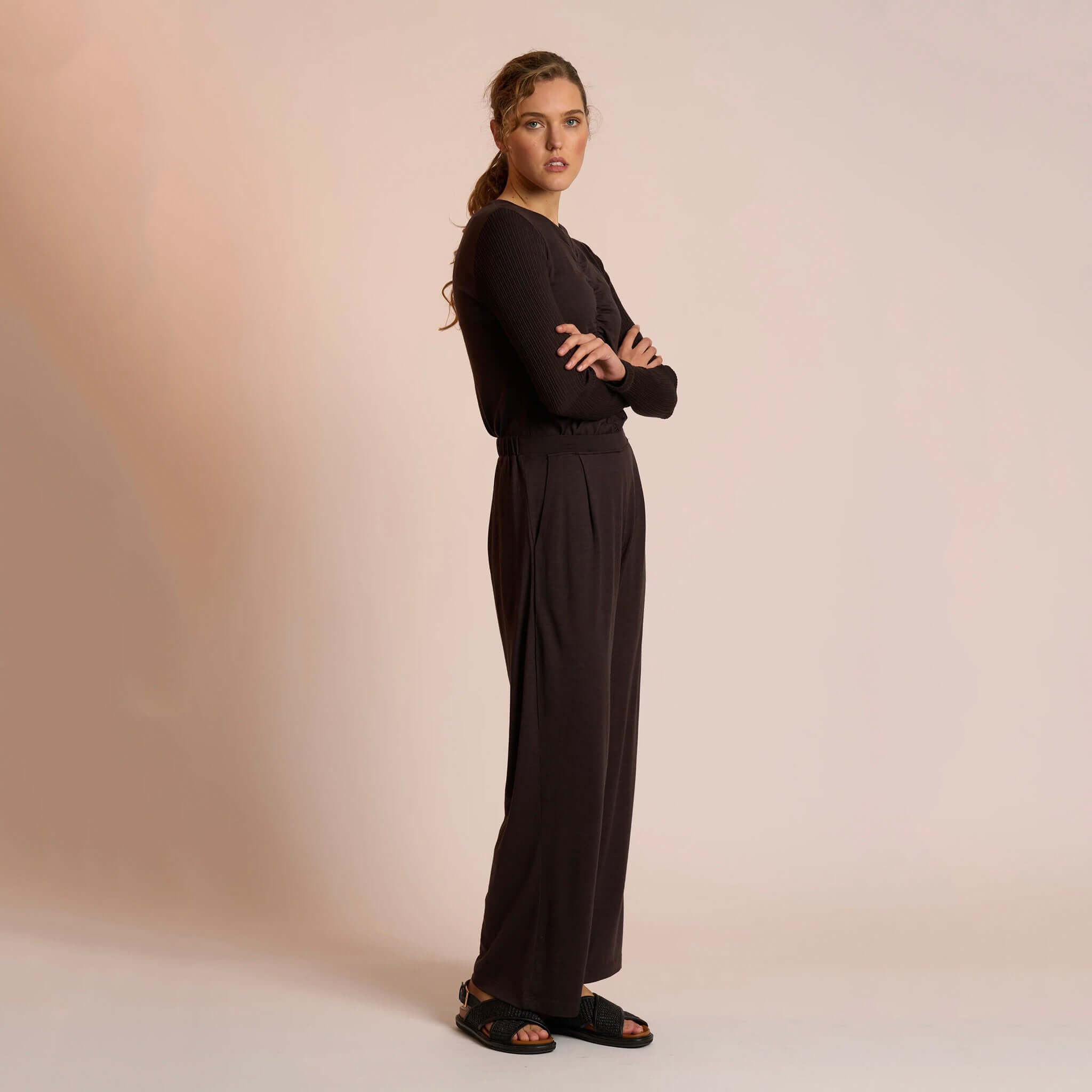 Alt Tag: Neris Merino Lounge Pants - Bitter Sweet worn by model, full-length side view, soft merino wool relaxed fit trousers