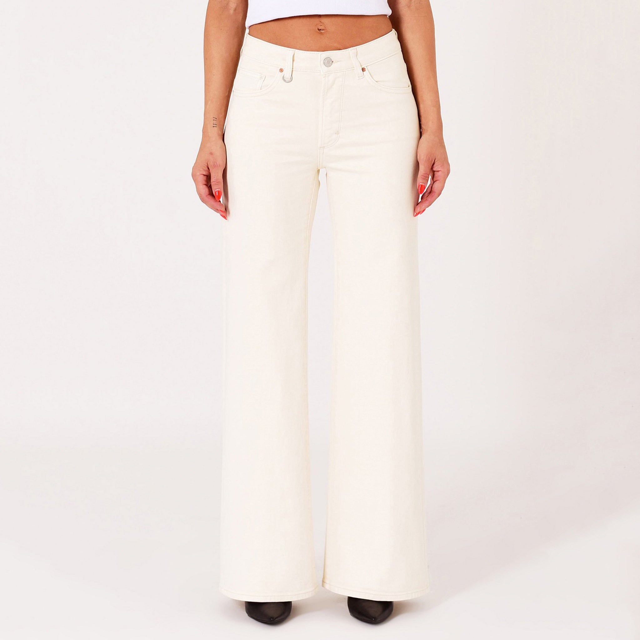 White wide-leg jeans worn by a person on a white background