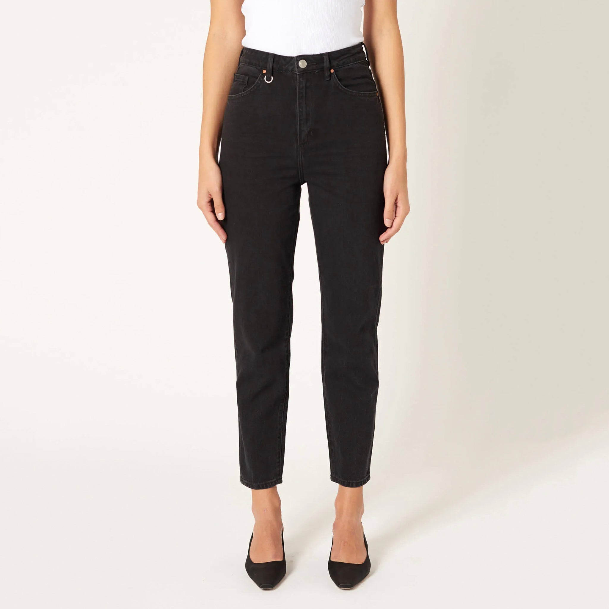 A female model wearing a white singlet and black jeans. The singlet is sleeveless with a slim fit and wide rib binding at the hem.