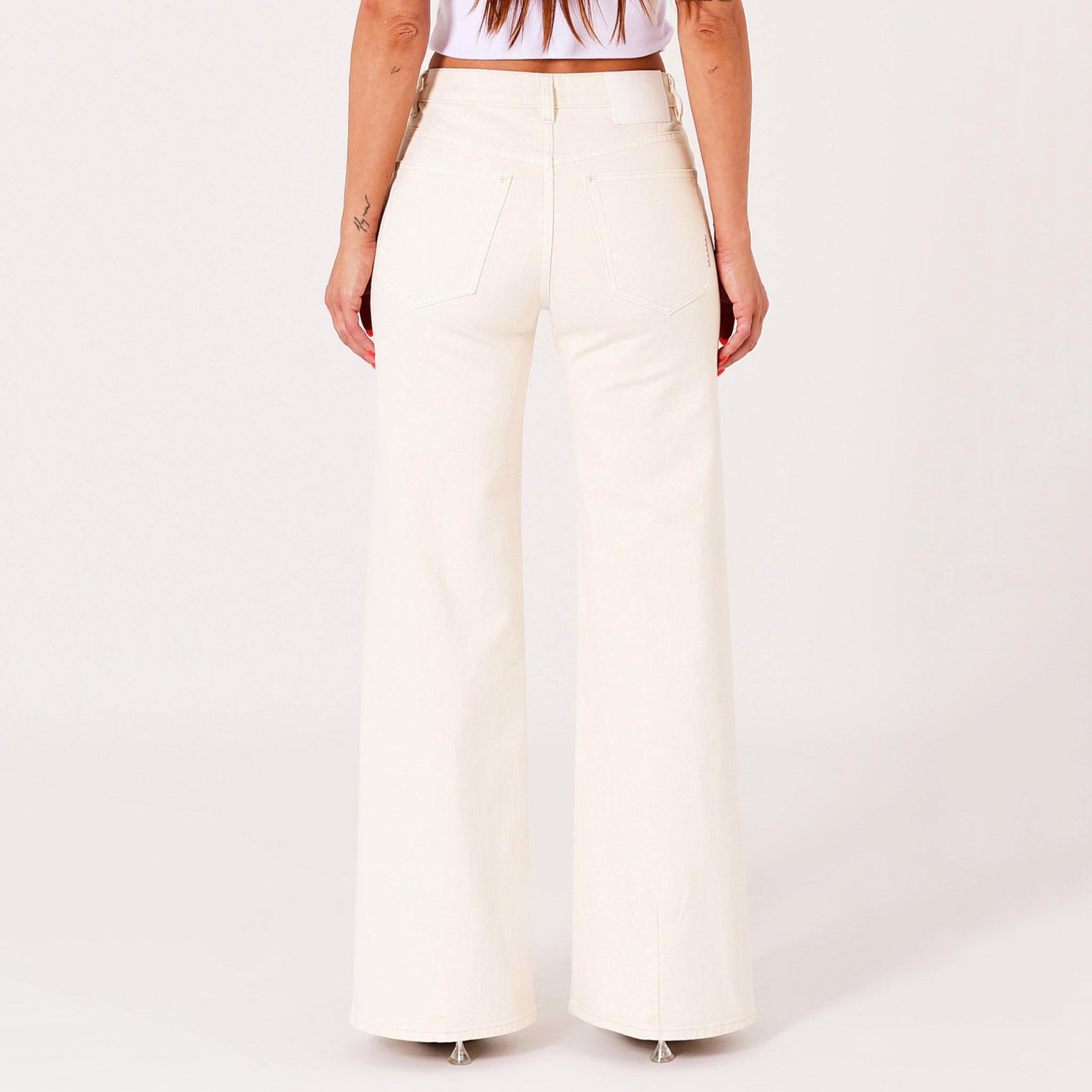 Person wearing white wide-leg pants on a plain background