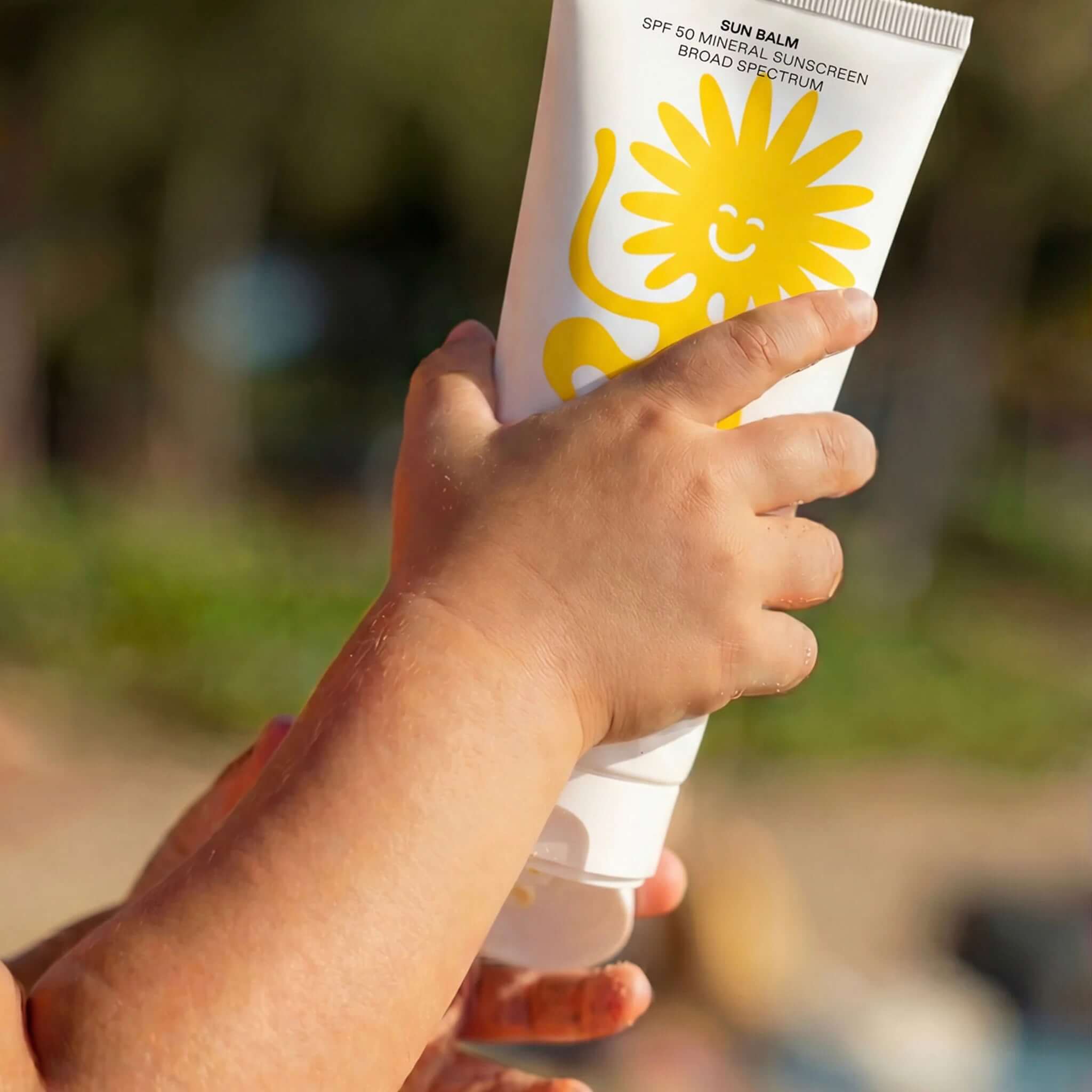 Alt Tag: Child holding Noody Sun Balm SPF 50 mineral sunscreen tube with non-nano zinc oxide, gentle broad-spectrum UVA/UVB protection