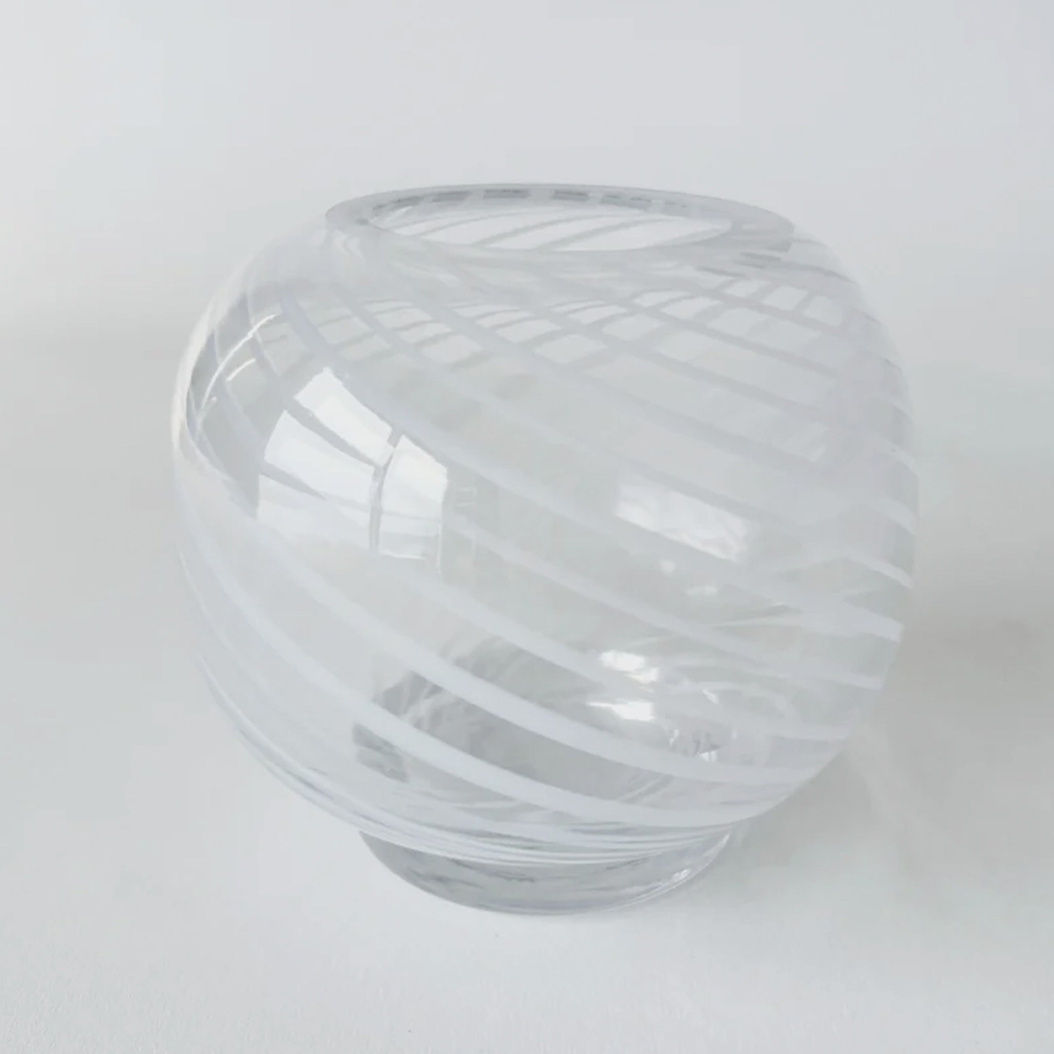 Clear glass vase with ribbed texture on a white background