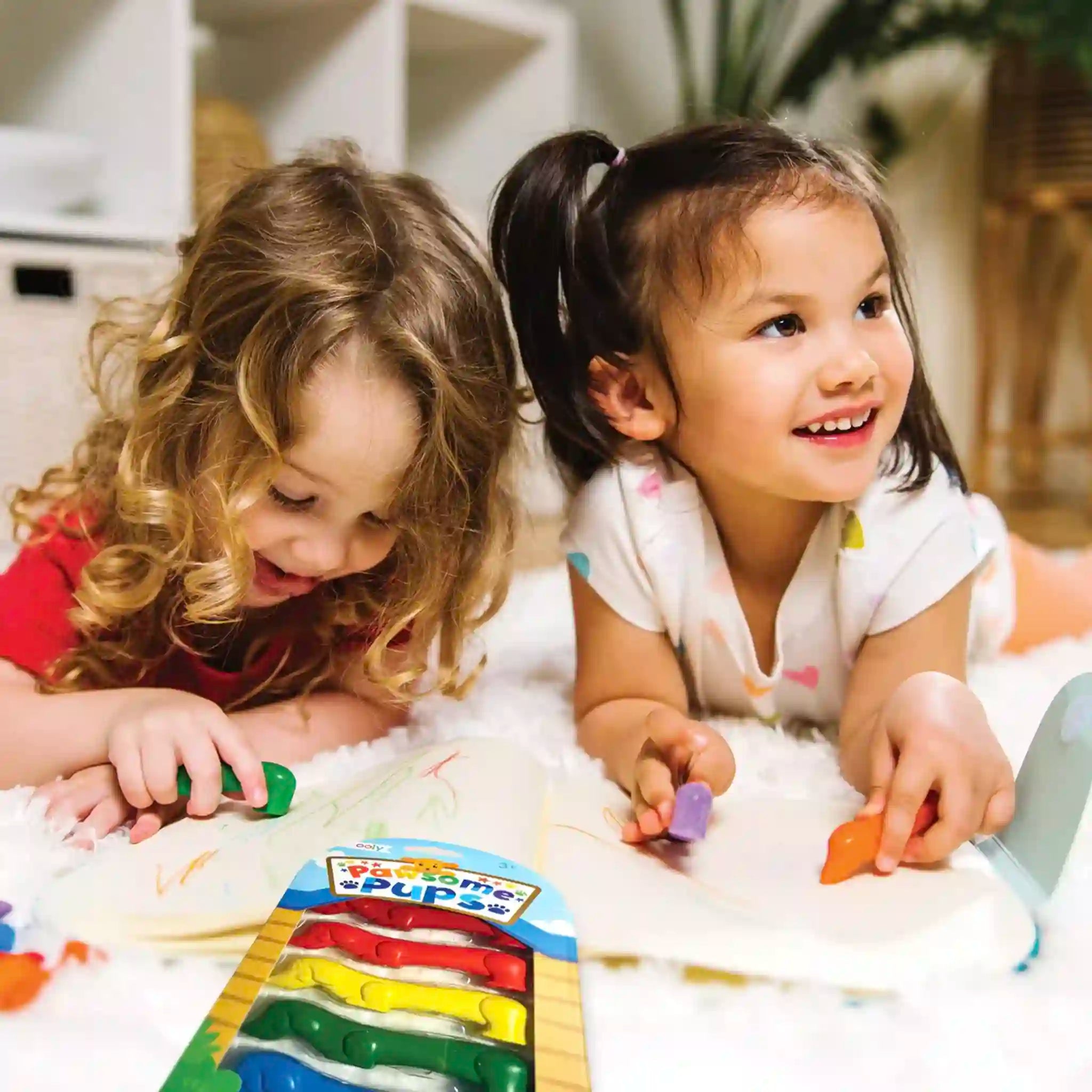 Two young girls playing with colorful toys on a carpeted floor.