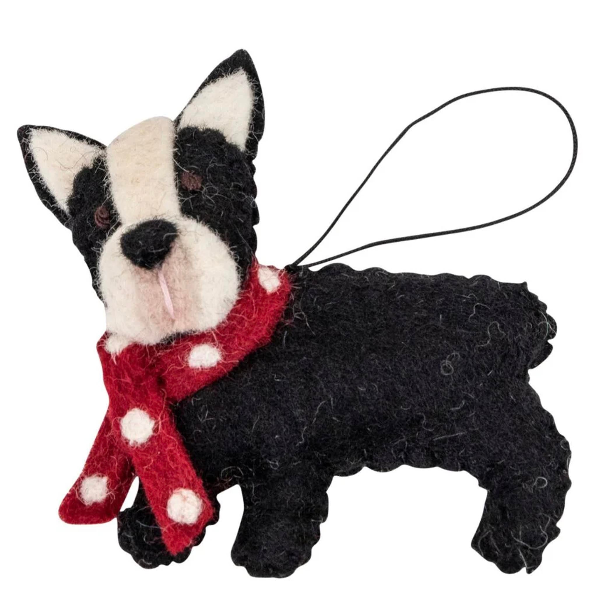 Black and white dog figurine with a red scarf on a white background