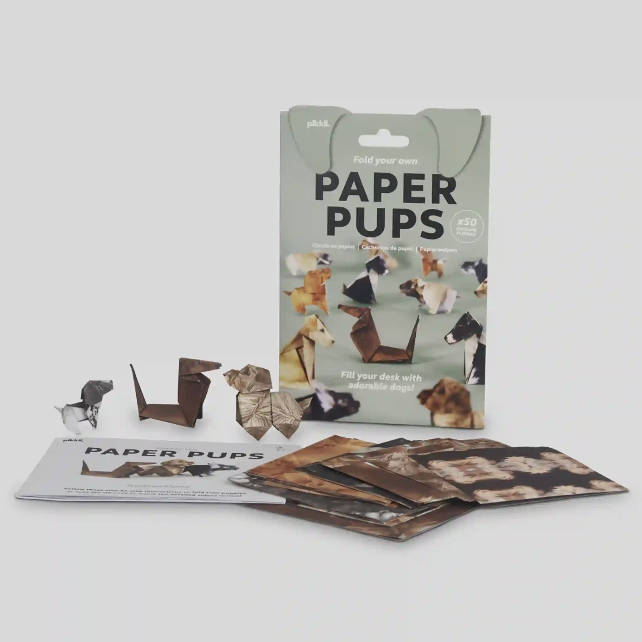 Packaging of 'Paper Pups' with folded paper dog figures on a white background