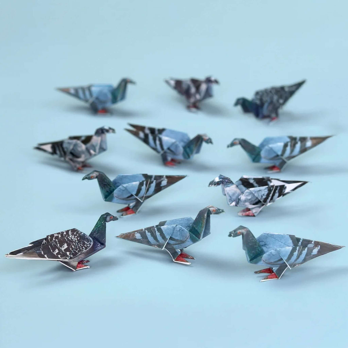A group of Pikkii Origami Paper Pigeons in various realistic patterns, showcasing foldable art for desk decor.