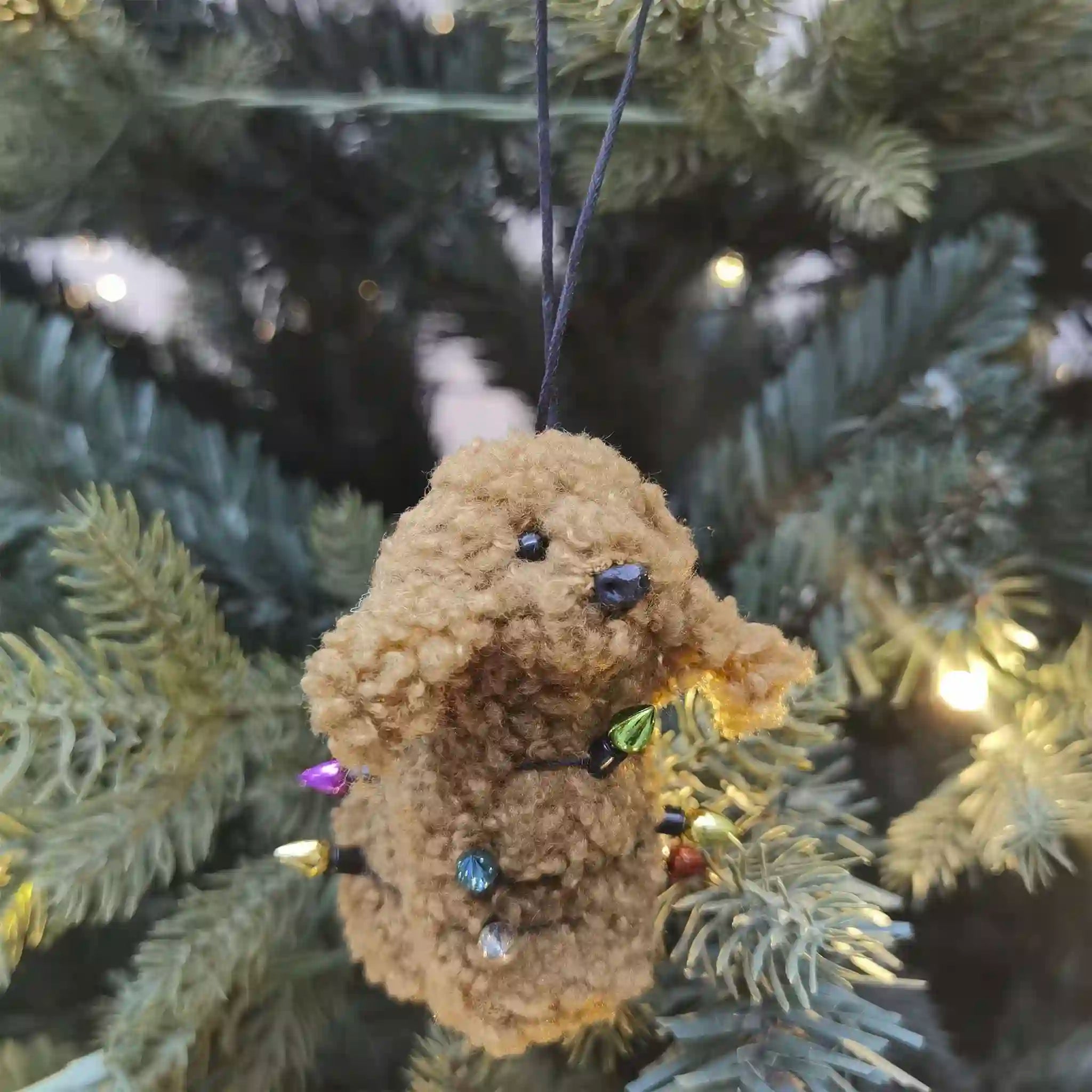 Teddy bear ornament with colorful lights on a Christmas tree