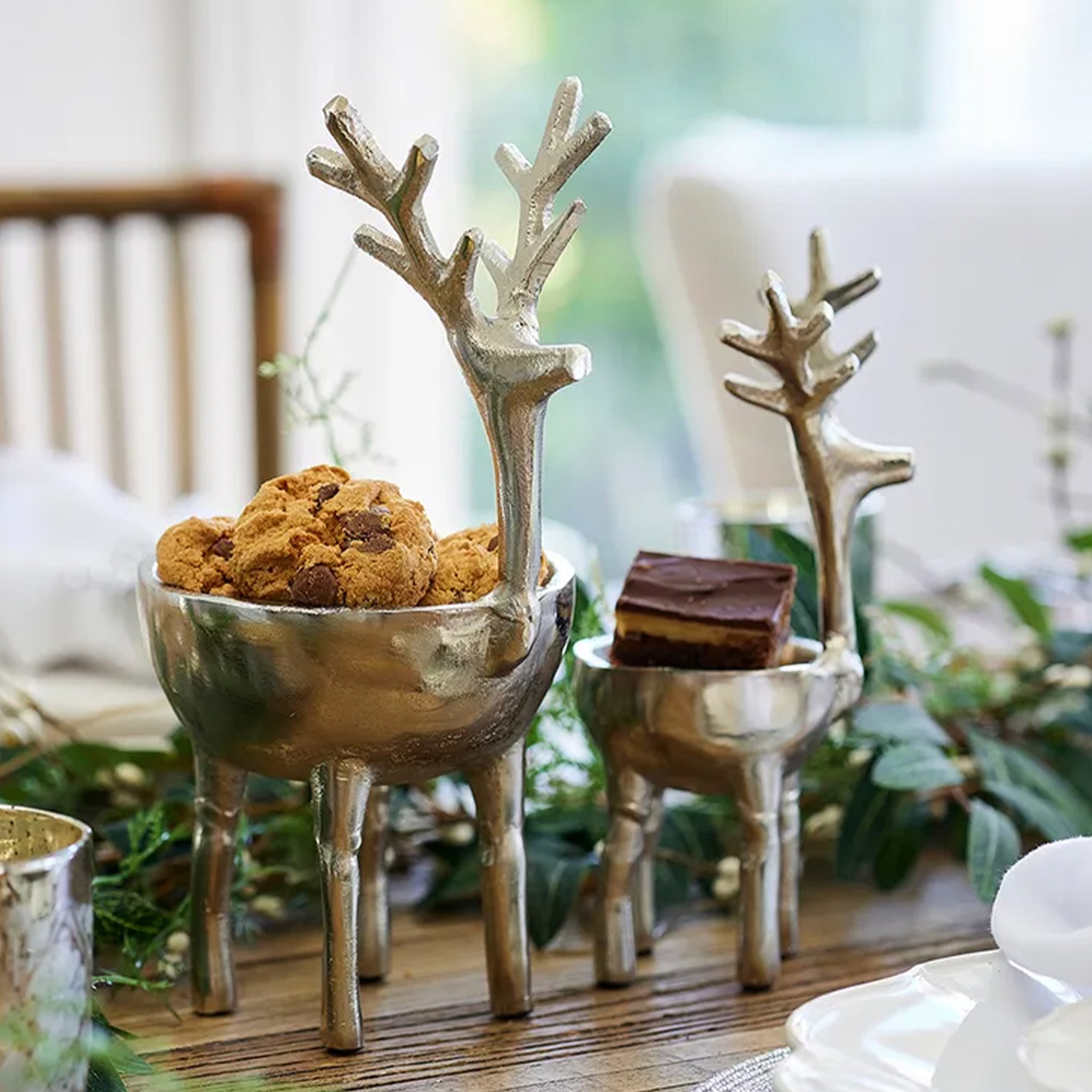 Decorative deer antler bowls on a table with cookies and chocolate bars.