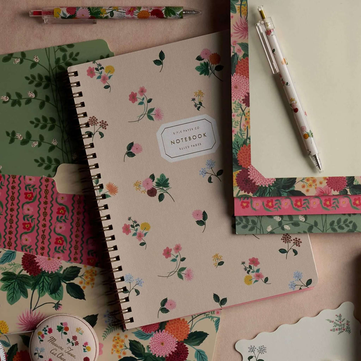 Rifle Paper Spiral Notebook - Ditsy Dahlia surrounded by floral stationery and pens.