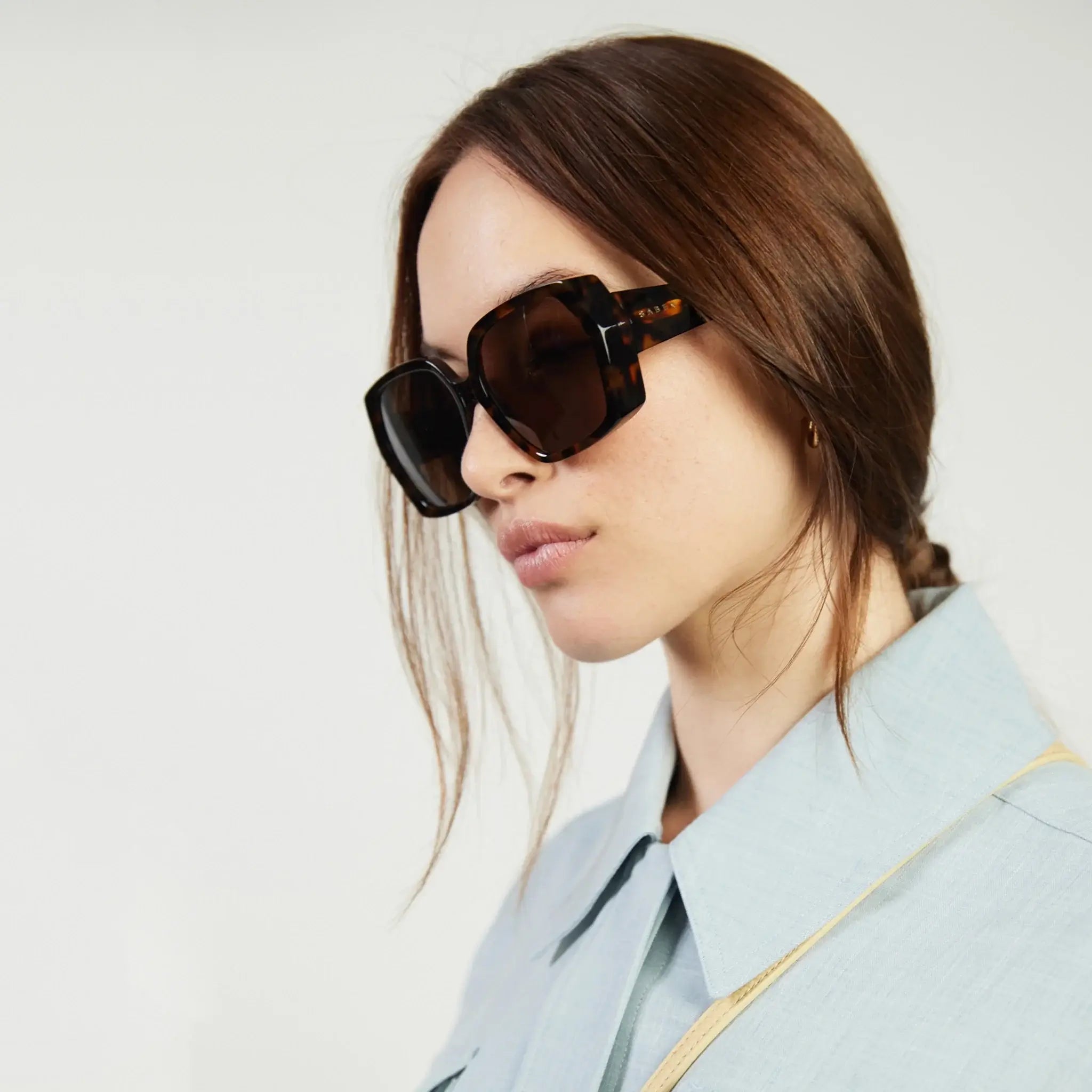Woman wearing sunglasses with a neutral background
