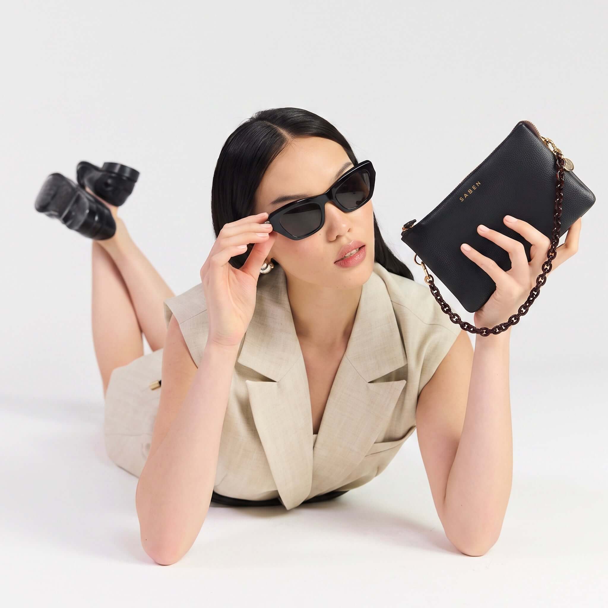 Saben Feature Chain Handle - Cacao Link showcased with a model wearing sunglasses, styled as a chic clutch.