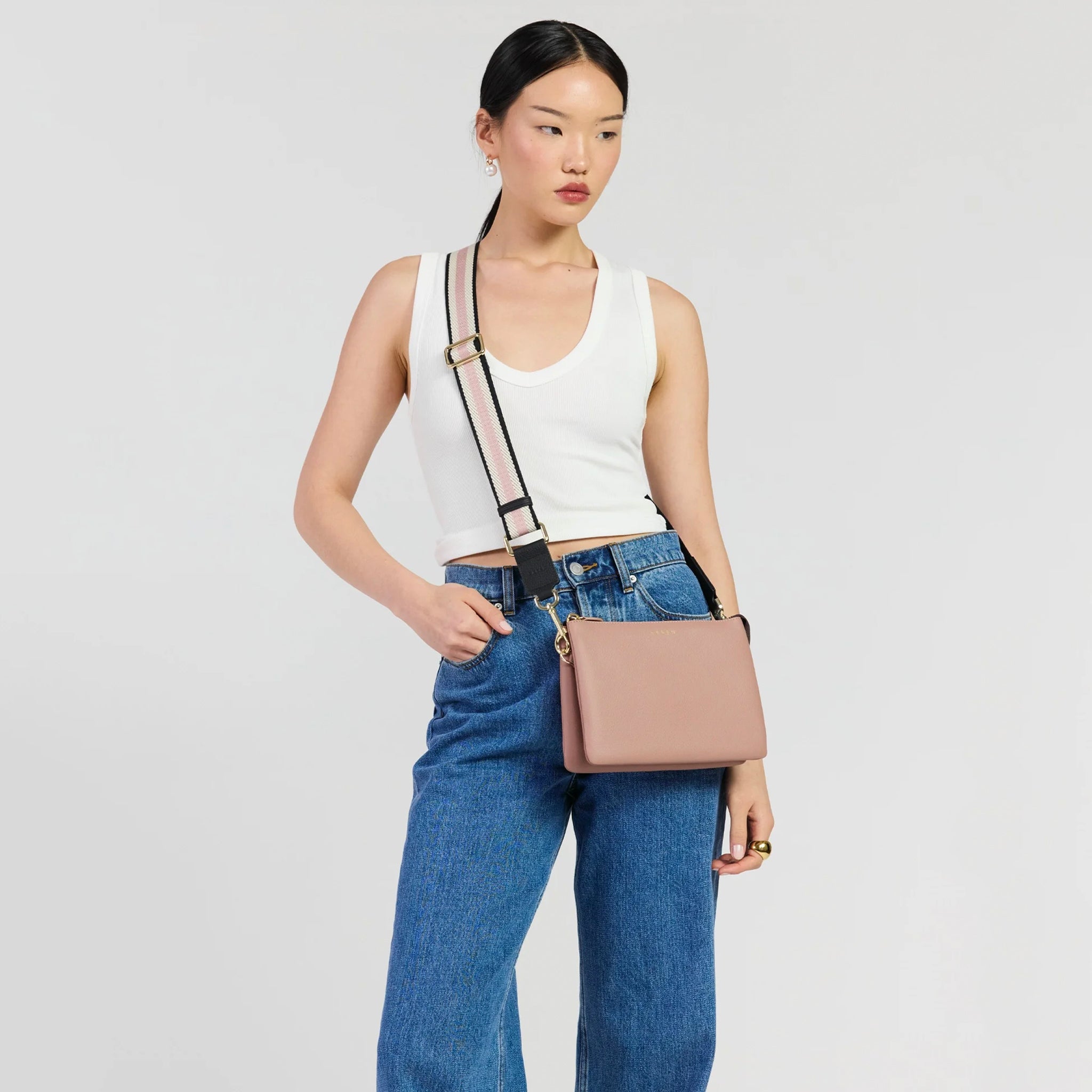 Saben Feature Webbing Strap - Black, Rosewater & White Stripe featured on a woman with a stylish bag.