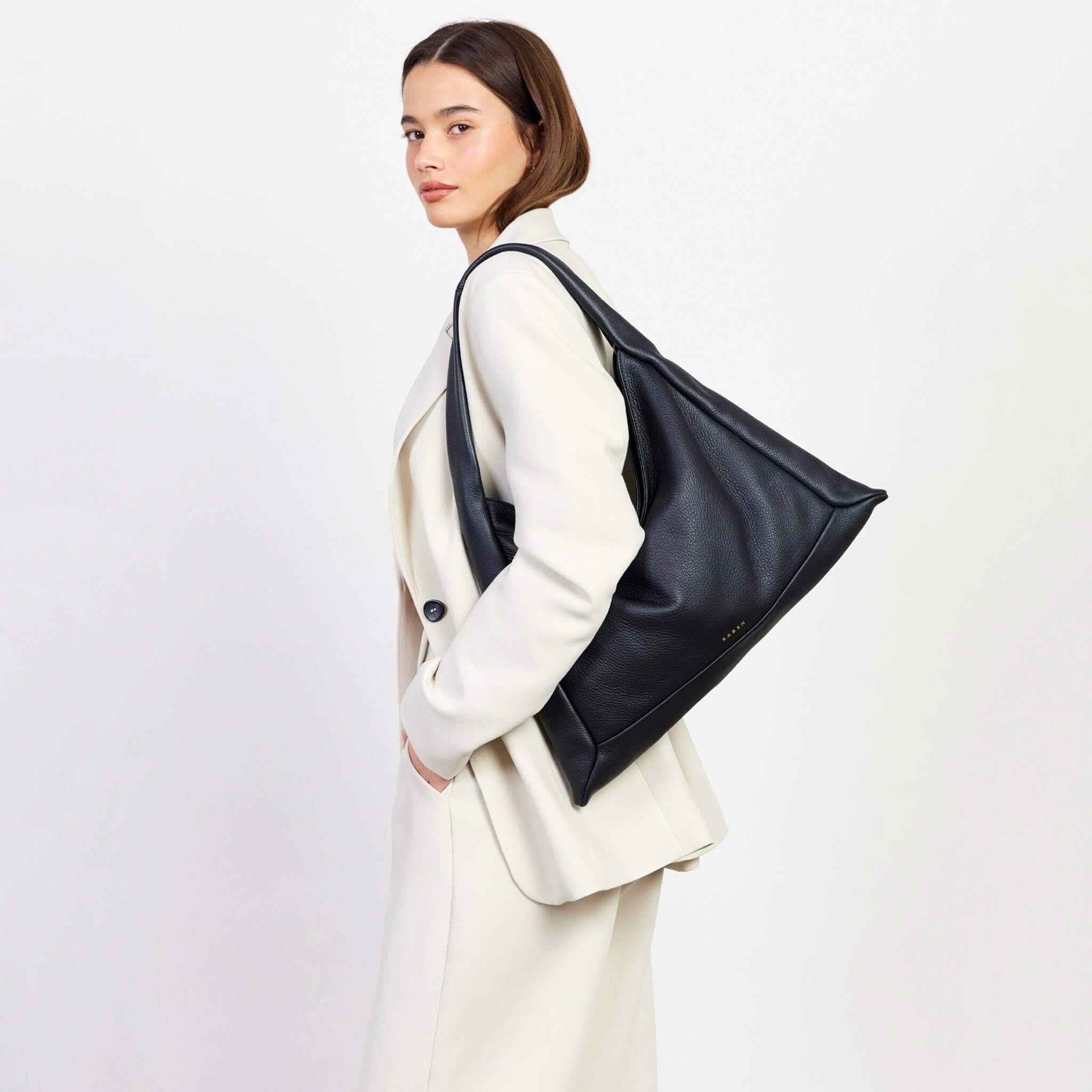Alt Tag: Saben Haze Shoulder Bag - Black Luxe black leather slouch shoulder bag worn on shoulder, minimalist luxe everyday carry