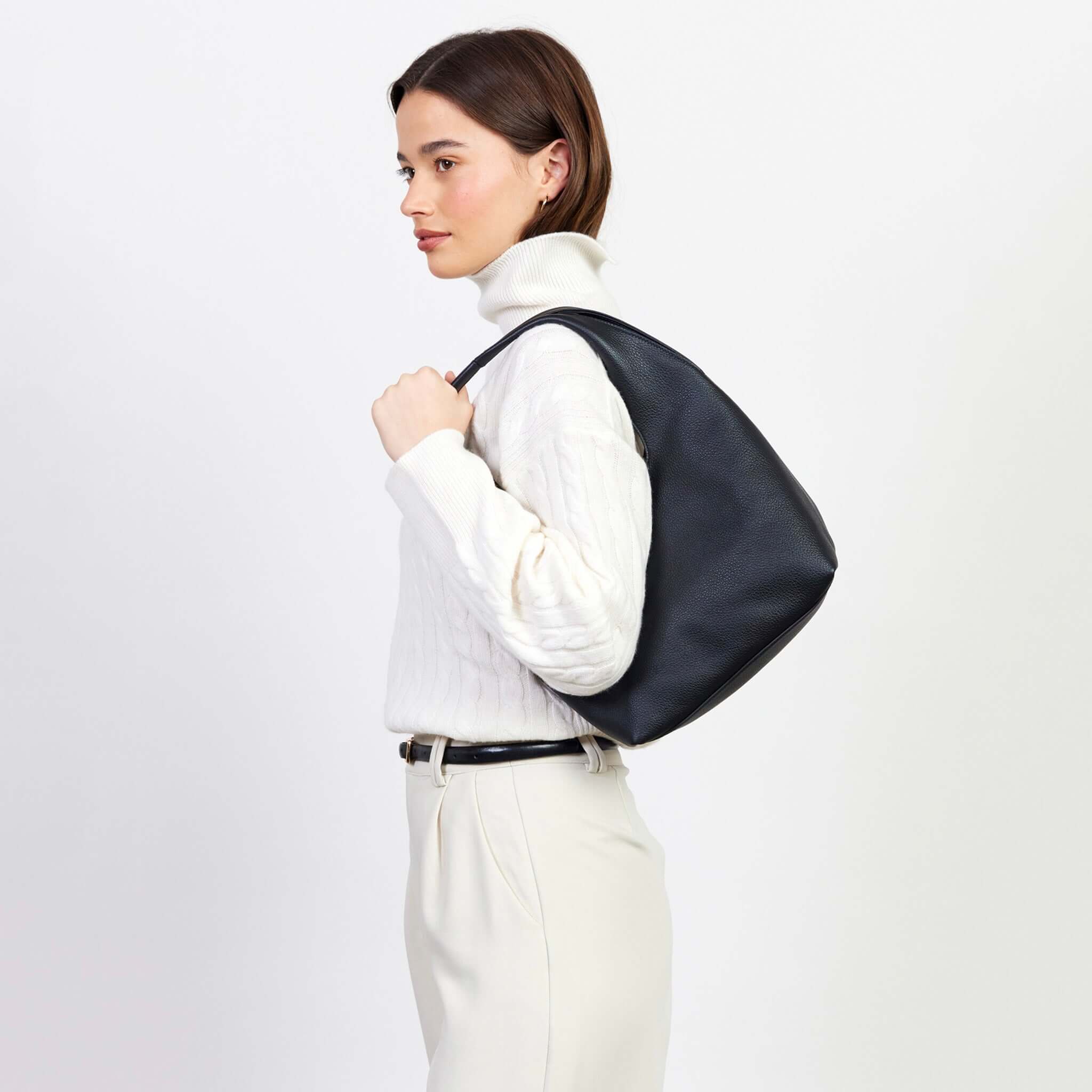 Alt Tag: Saben Kiki Shoulder Bag - Black slouchy black shoulder bag worn on shoulder by model, relaxed silhouette for work to weekend