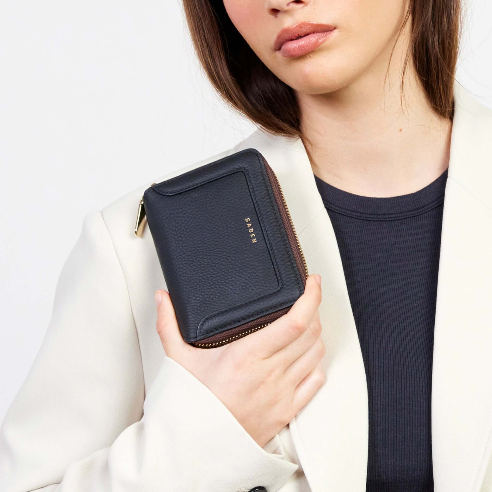 Alt Tag: Saben Landry Wallet - Black premium black leather zip-around wallet with card slots and coin pocket held in hand