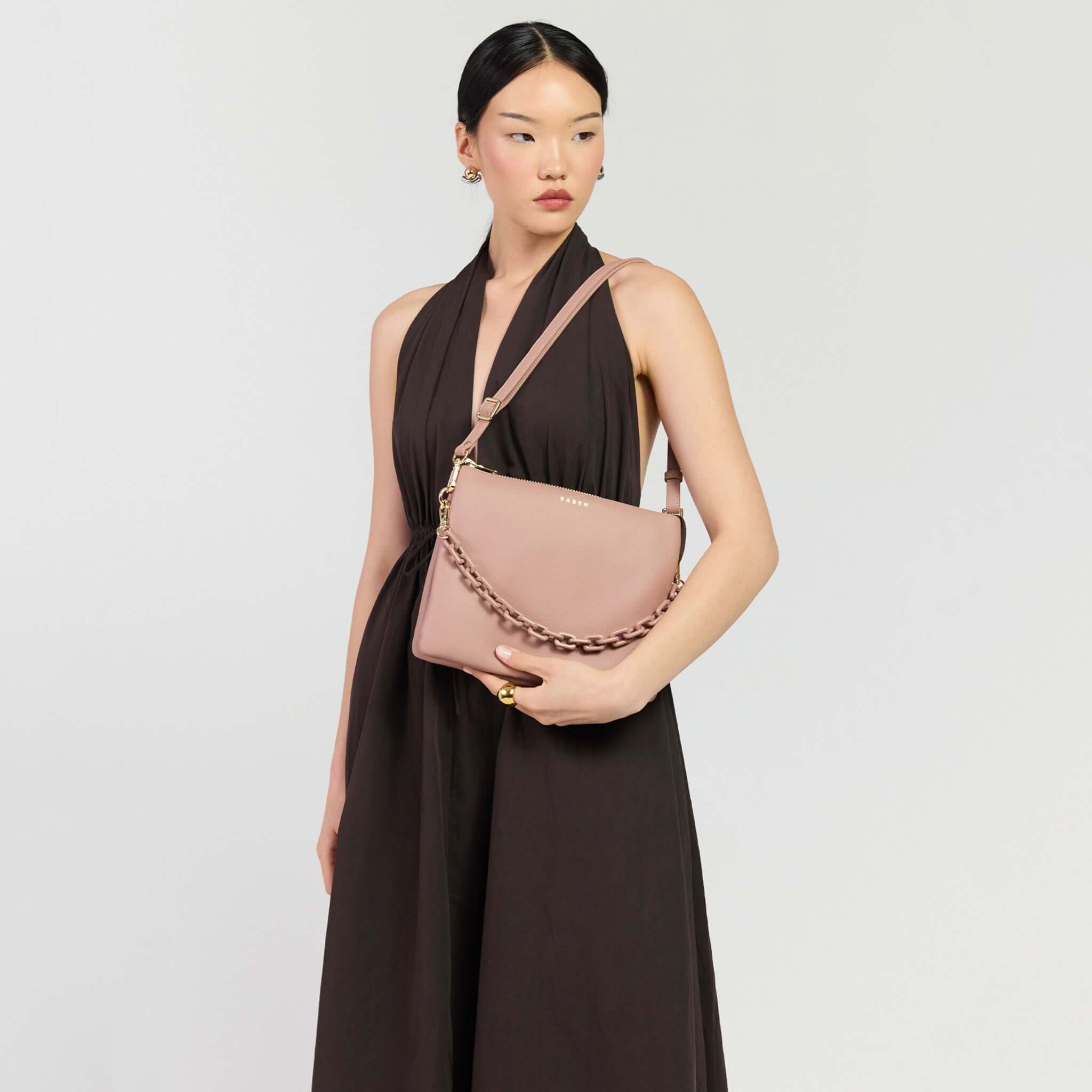 Saben Matilda Crossbody Bag - Rosewater with Tonal Chain worn by a model in a black dress.