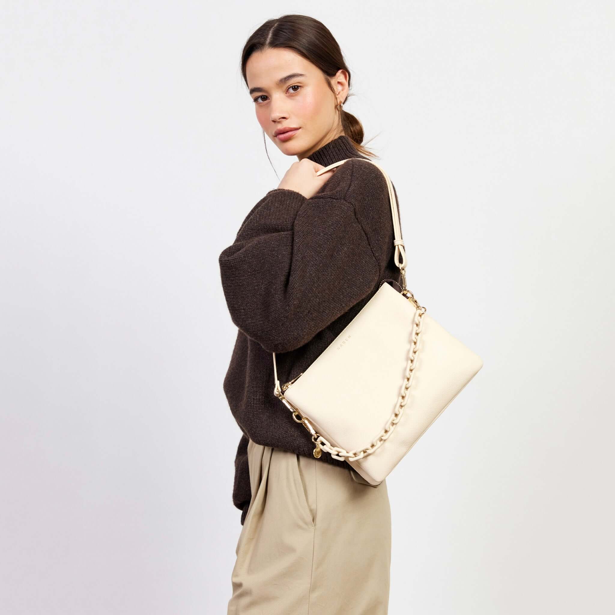 Alt Tag: Saben Matilda Crossbody Bag - Vanilla with Tonal Chain on model, vanilla leather crossbody with tonal chain strap