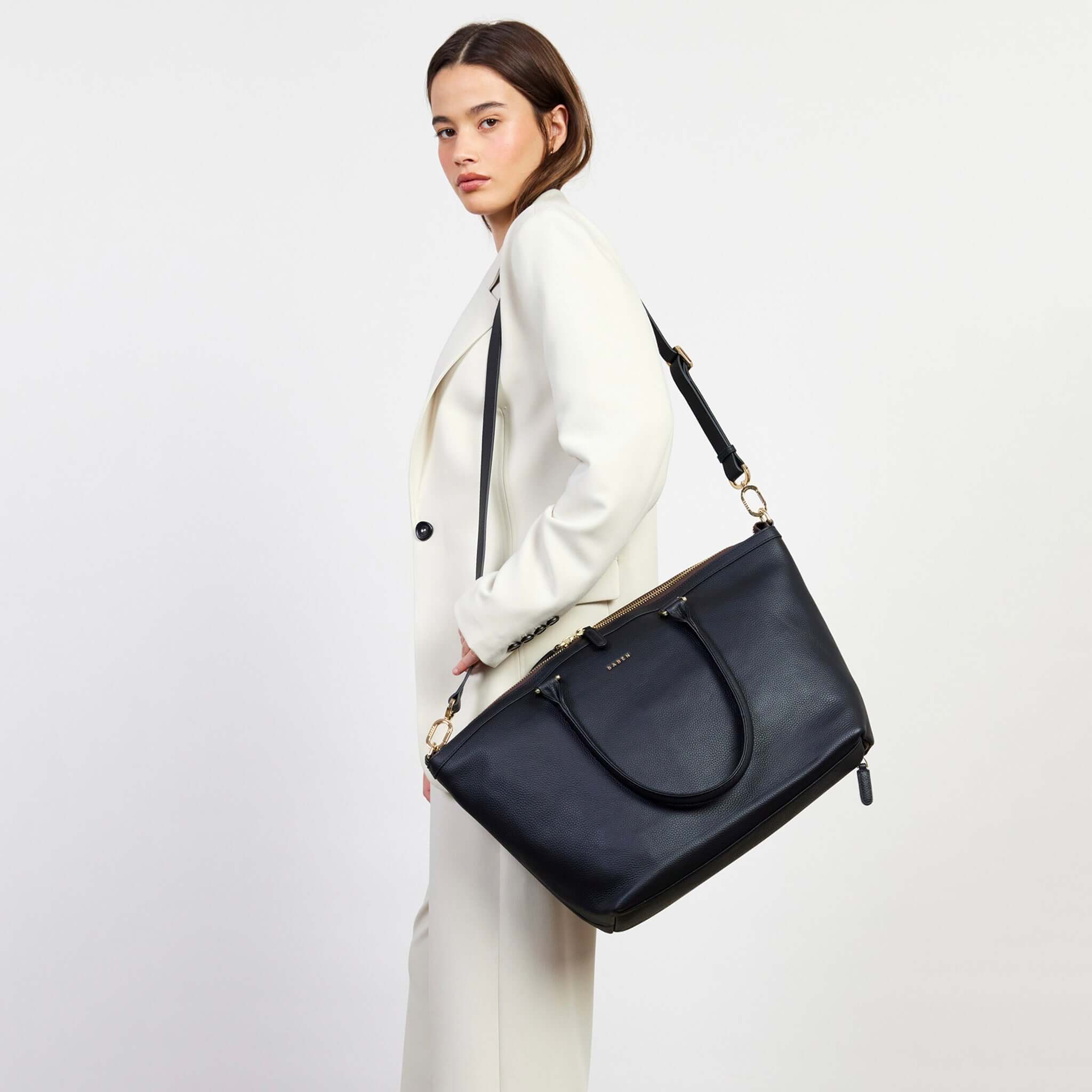 Alt Tag: Saben Milan Carry-All Bag - Black worn crossbody on model, spacious carry-all tote with shoulder strap