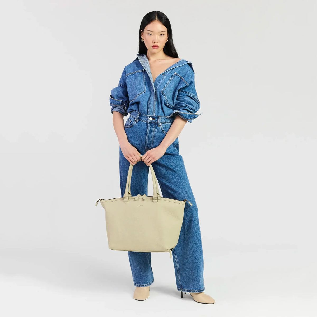 Saben Milan Carry-All Bag - Oyster held by a model in denim, front view