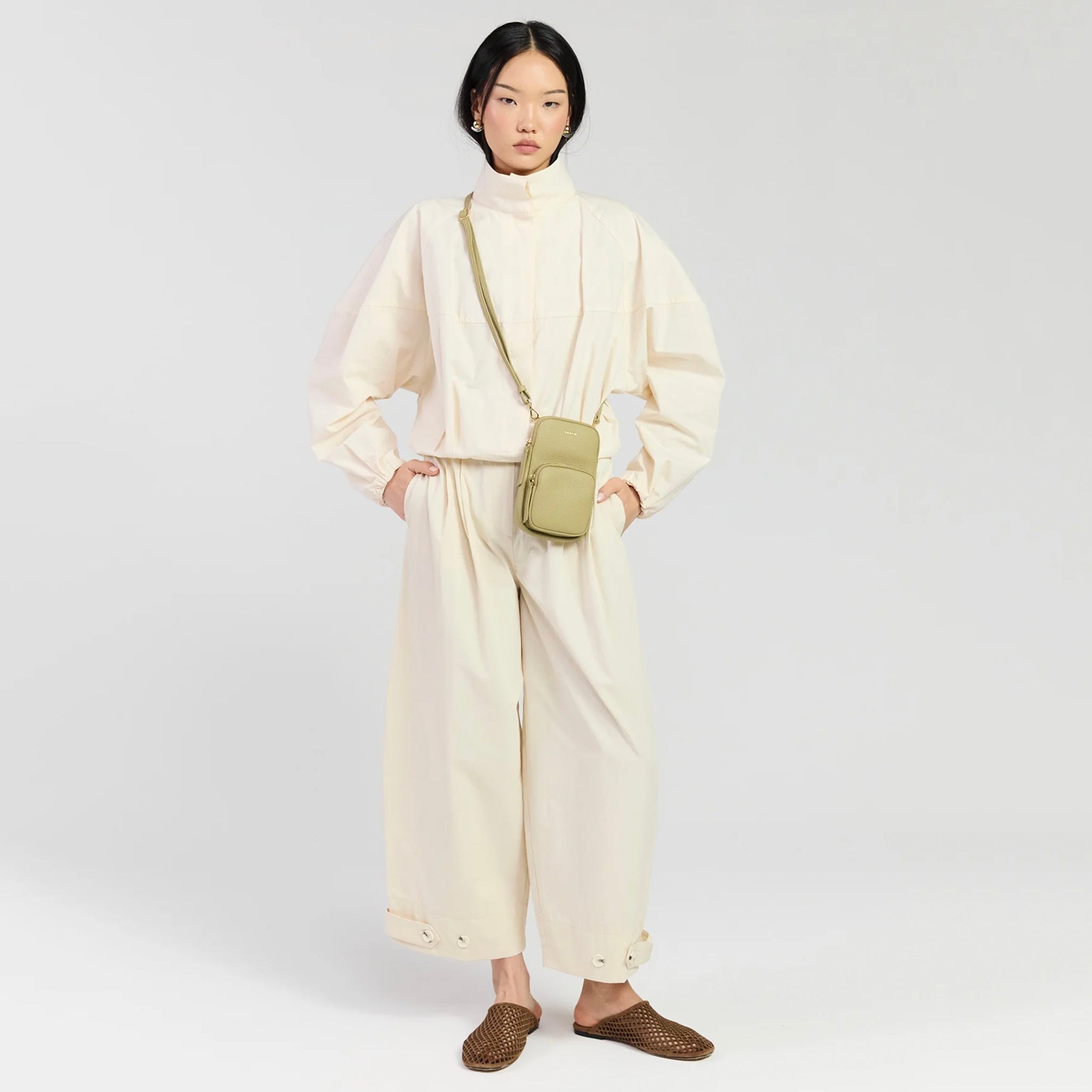 Saben Nikko Pocket Phone Sling - Willow Luxe worn by a model in cream outfit, showcasing its stylish and practical design.