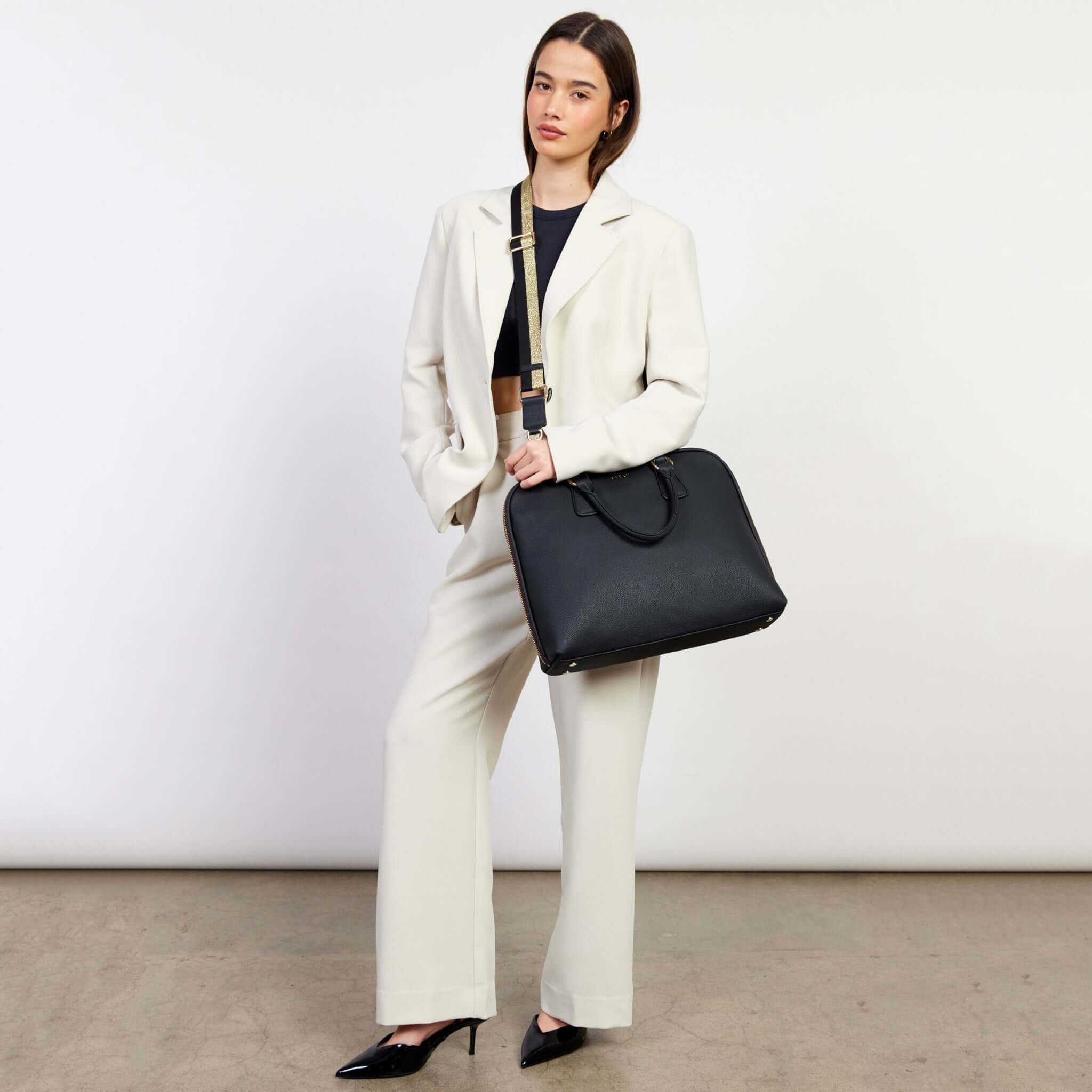 Saben Parker Briefcase - Black carried by model with crossbody strap, sleek black laptop briefcase for commuting and travel