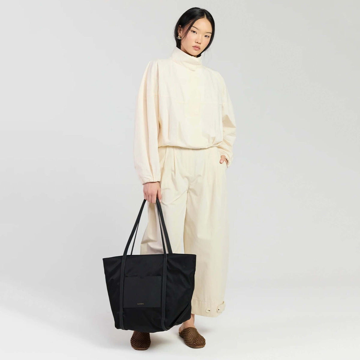 Saben Porter Tote - Black Recycled Nylon stylishly worn by a model in relaxed outfit, featuring multiple carrying options.